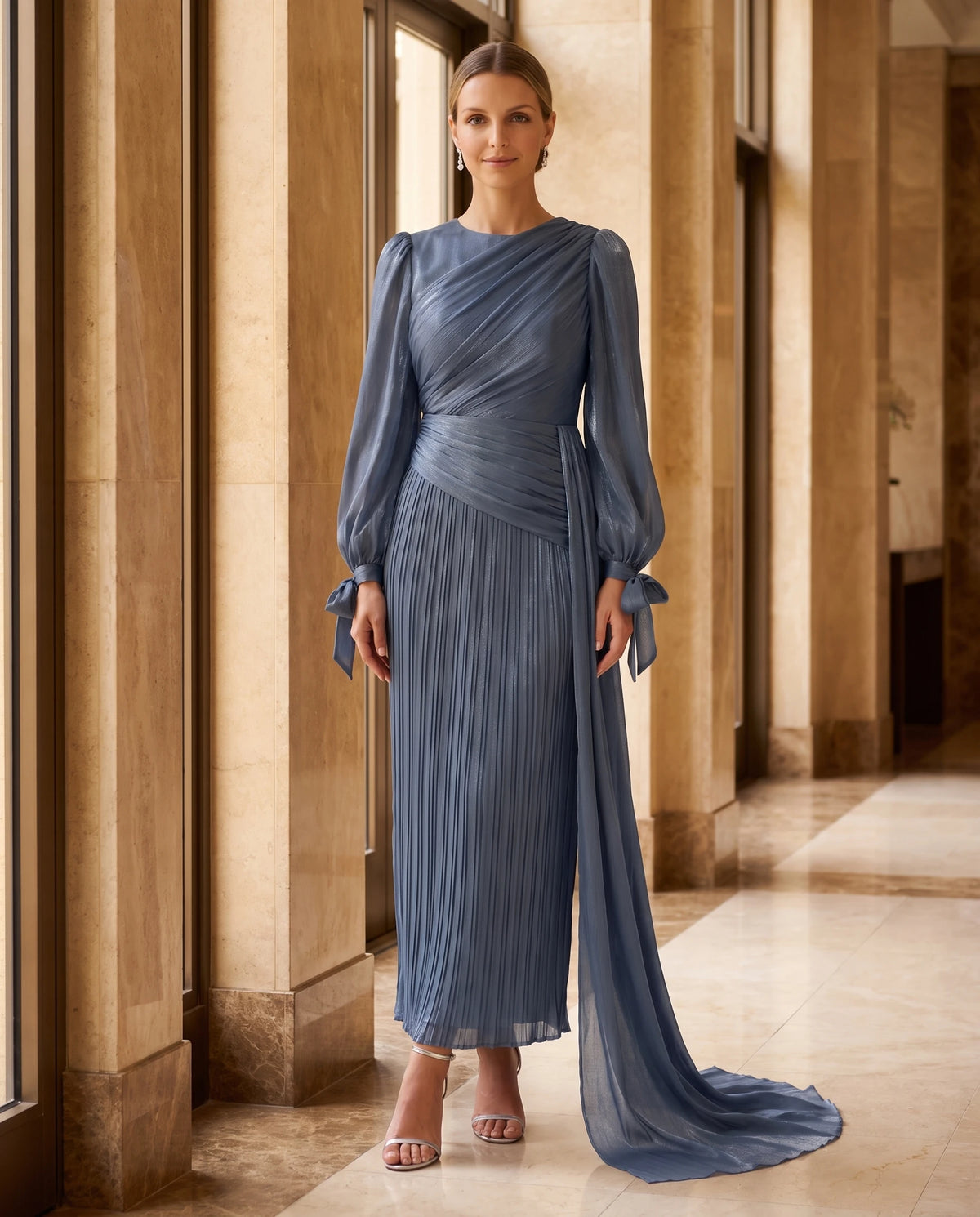 Langes drapiertes Plisseekleid mit Laternenärmeln Élia in Tintenblau, in einer Säulenhalle getragen