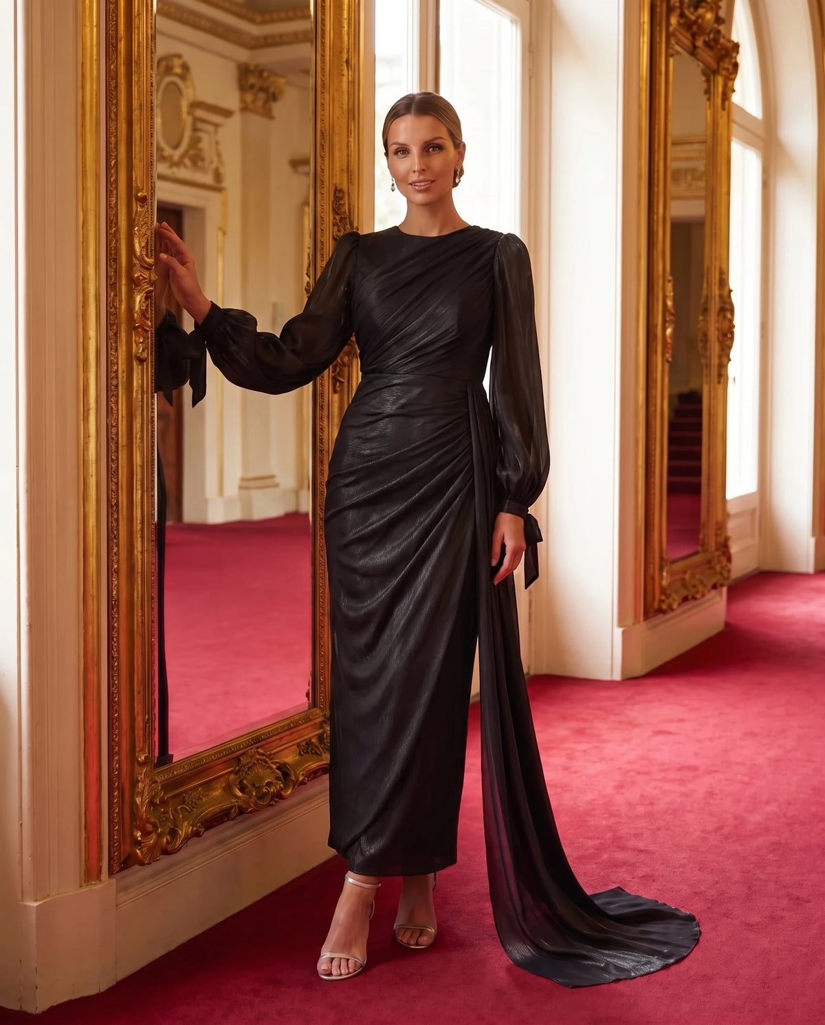 Robe longue plissée drapée à manches lanterne Élia en Noir, portée dans le foyer d'un opéra