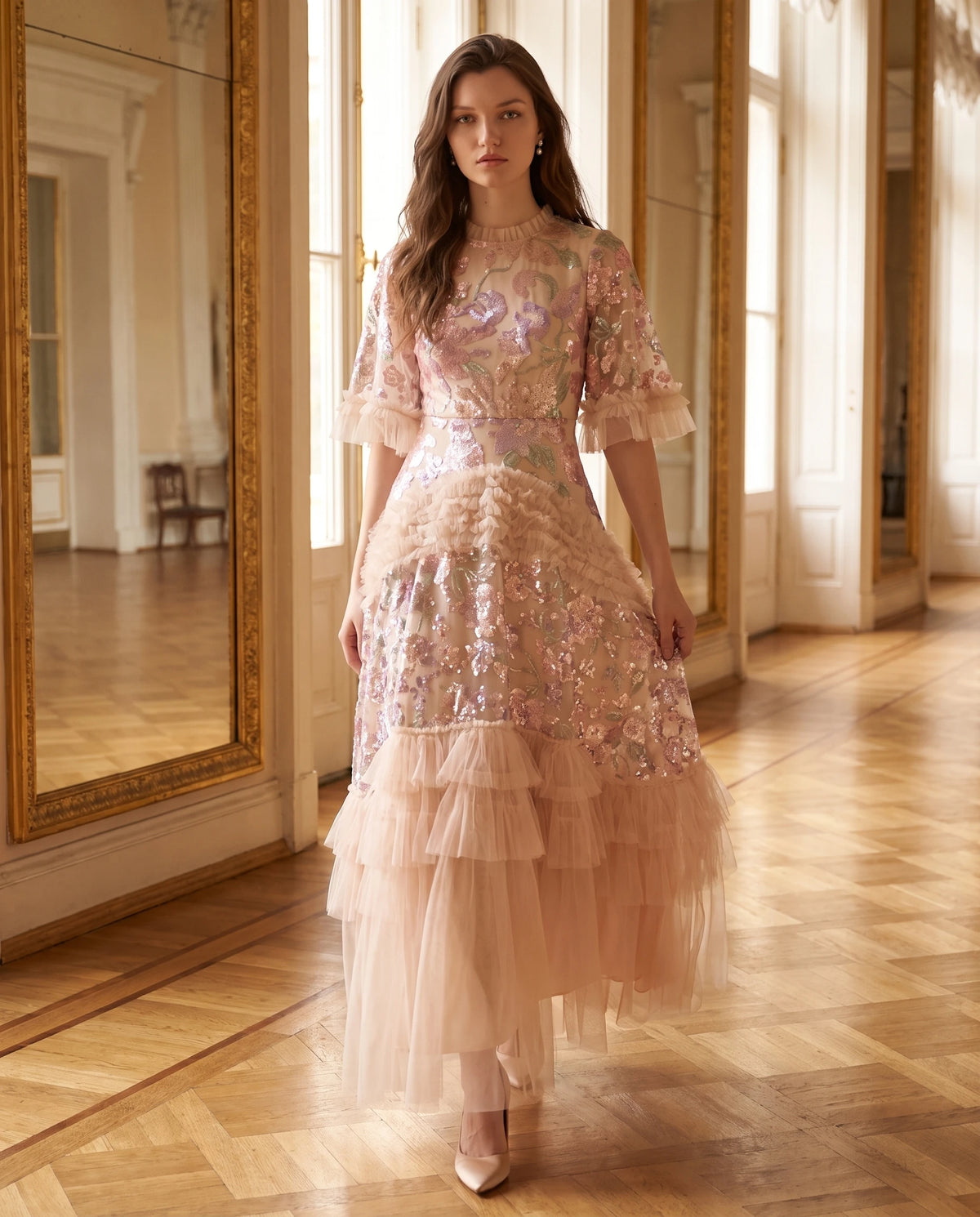Langes Tüllkleid mit Pailletten-Stickerei und Volants Rosalba in Champagner, in der Galerie eines Palastes getragen