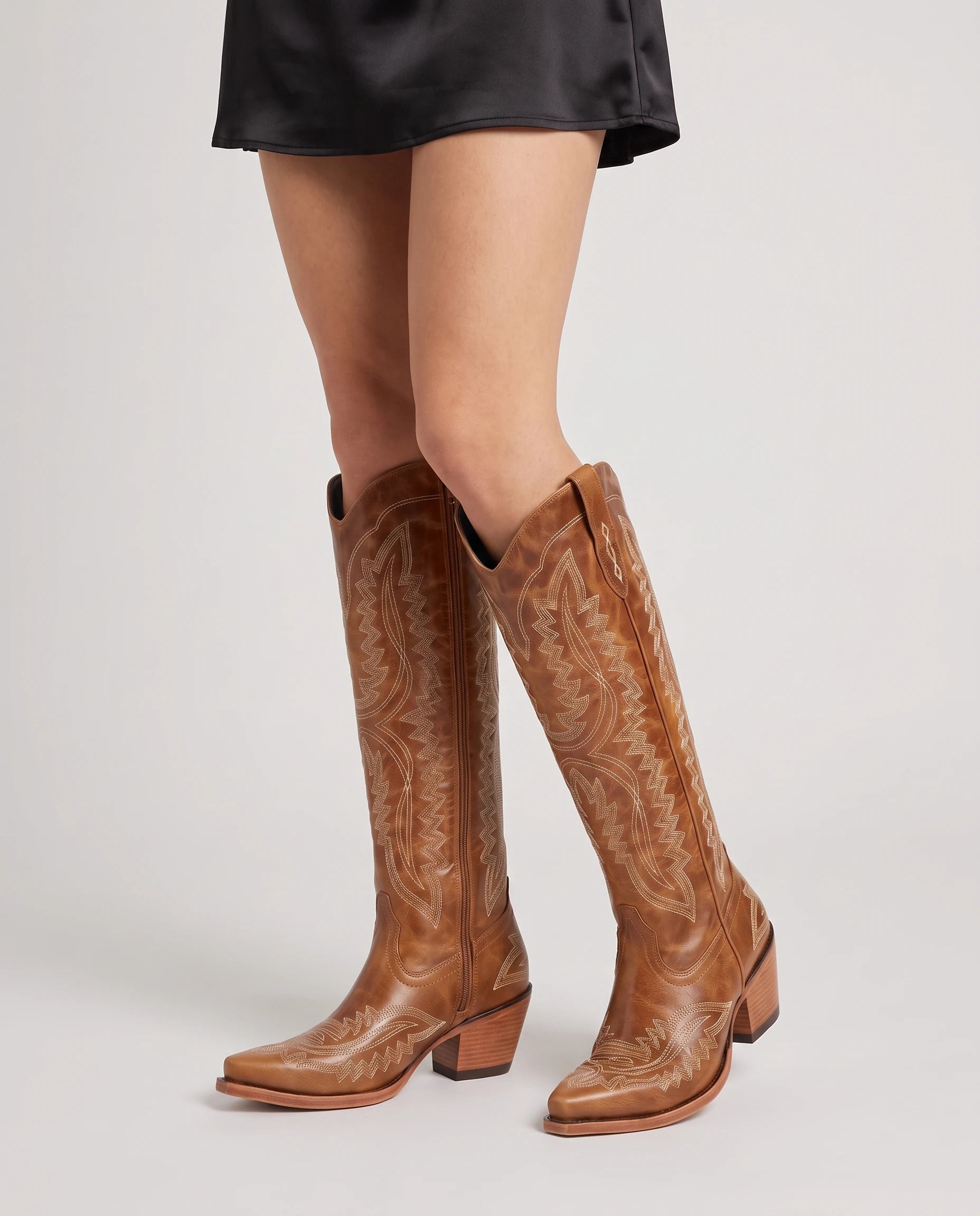 Bottes santiags hautes brodées effet cuir huilé Régine — Cognac, portées en plan rapproché