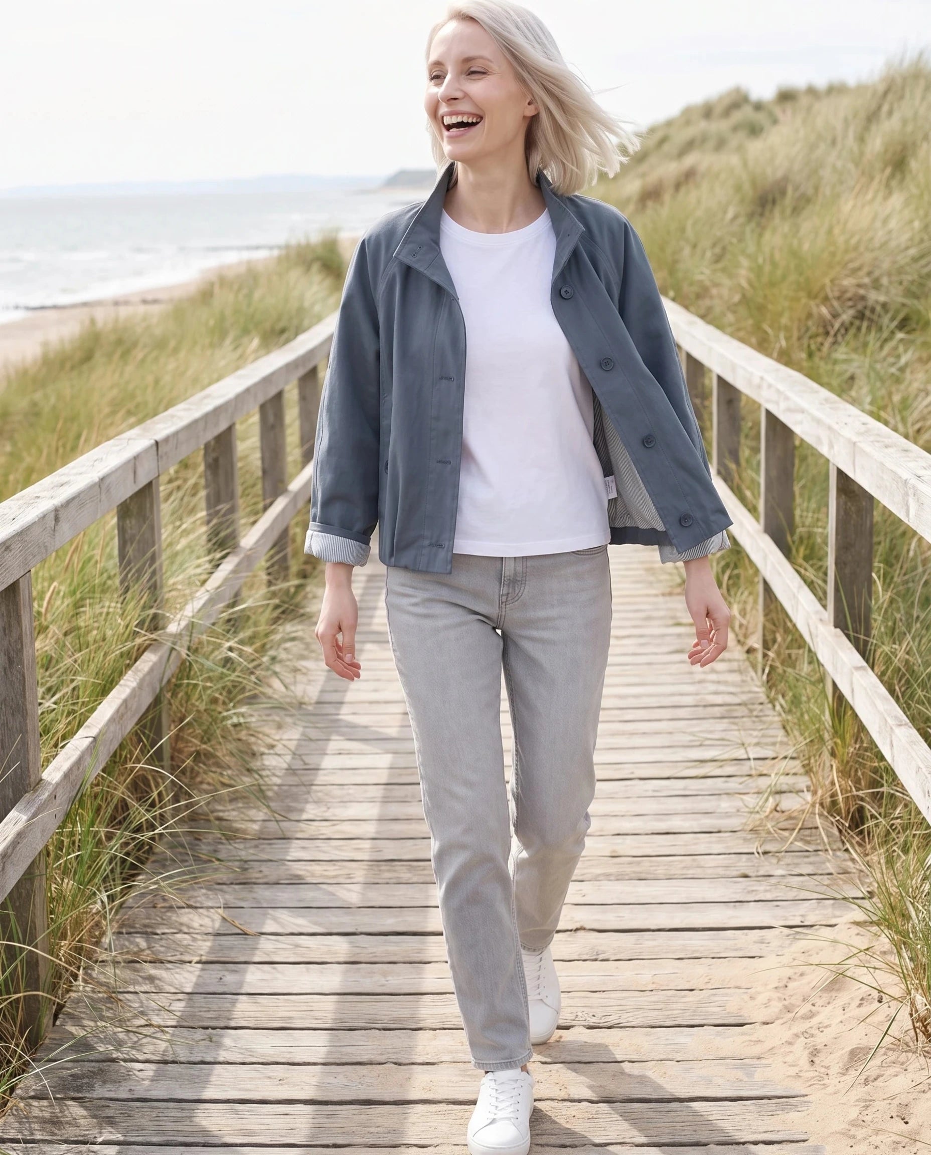 Trench court gris ardoise Raymonde, porté sur une digue en bois entre les dunes