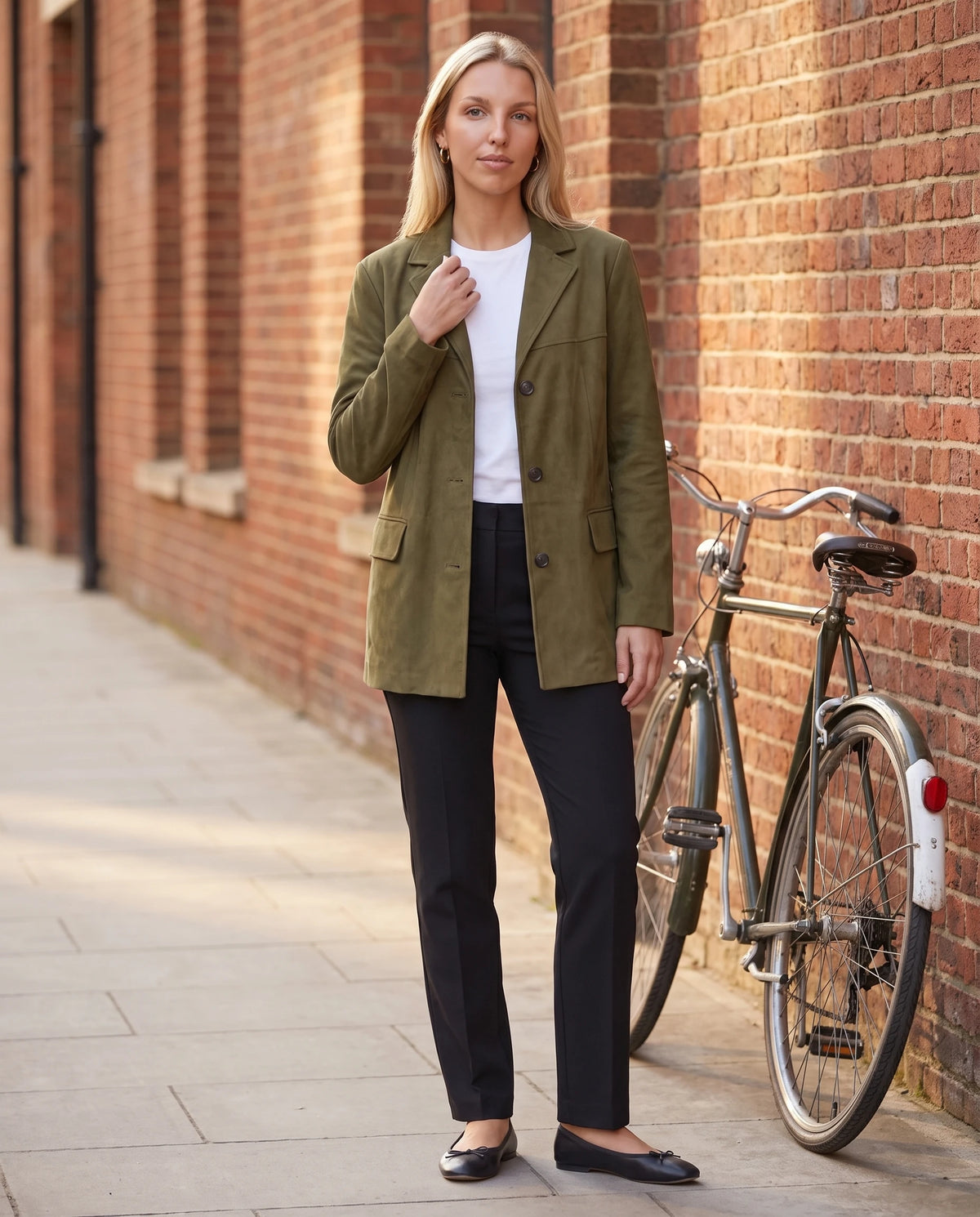 Blazerjacke aus Veloursimitat in Khaki Clothilde, getragen vor einer Backsteinwand