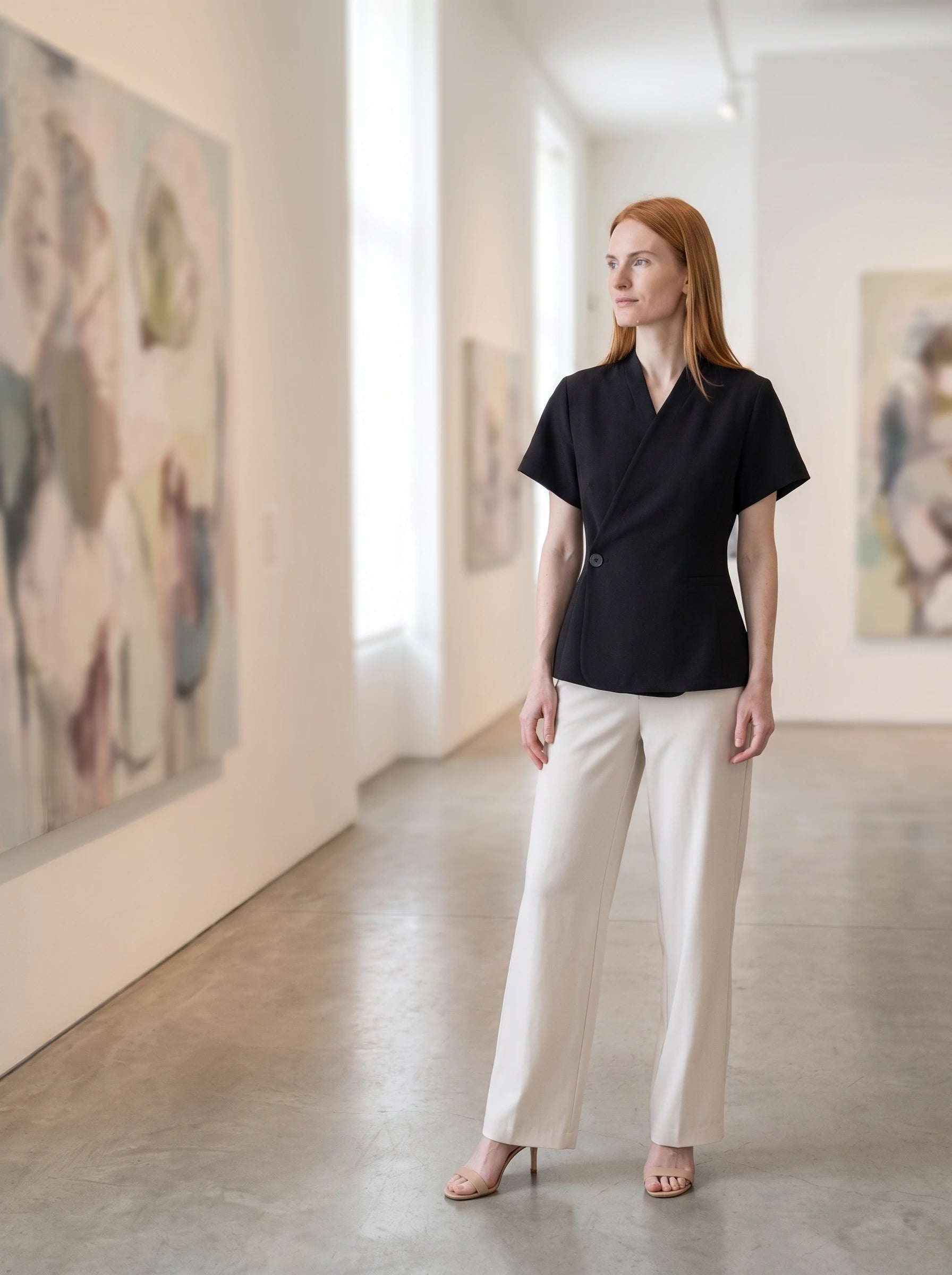 Veste cache-cœur noire Célimène, portée dans une galerie d'art lumineuse