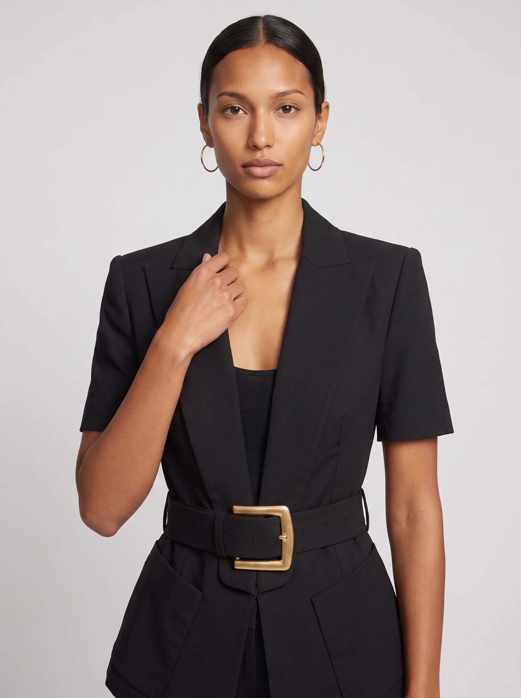Veste cintrée ceinturée à manches courtes noire Aimée, plan rapproché en studio