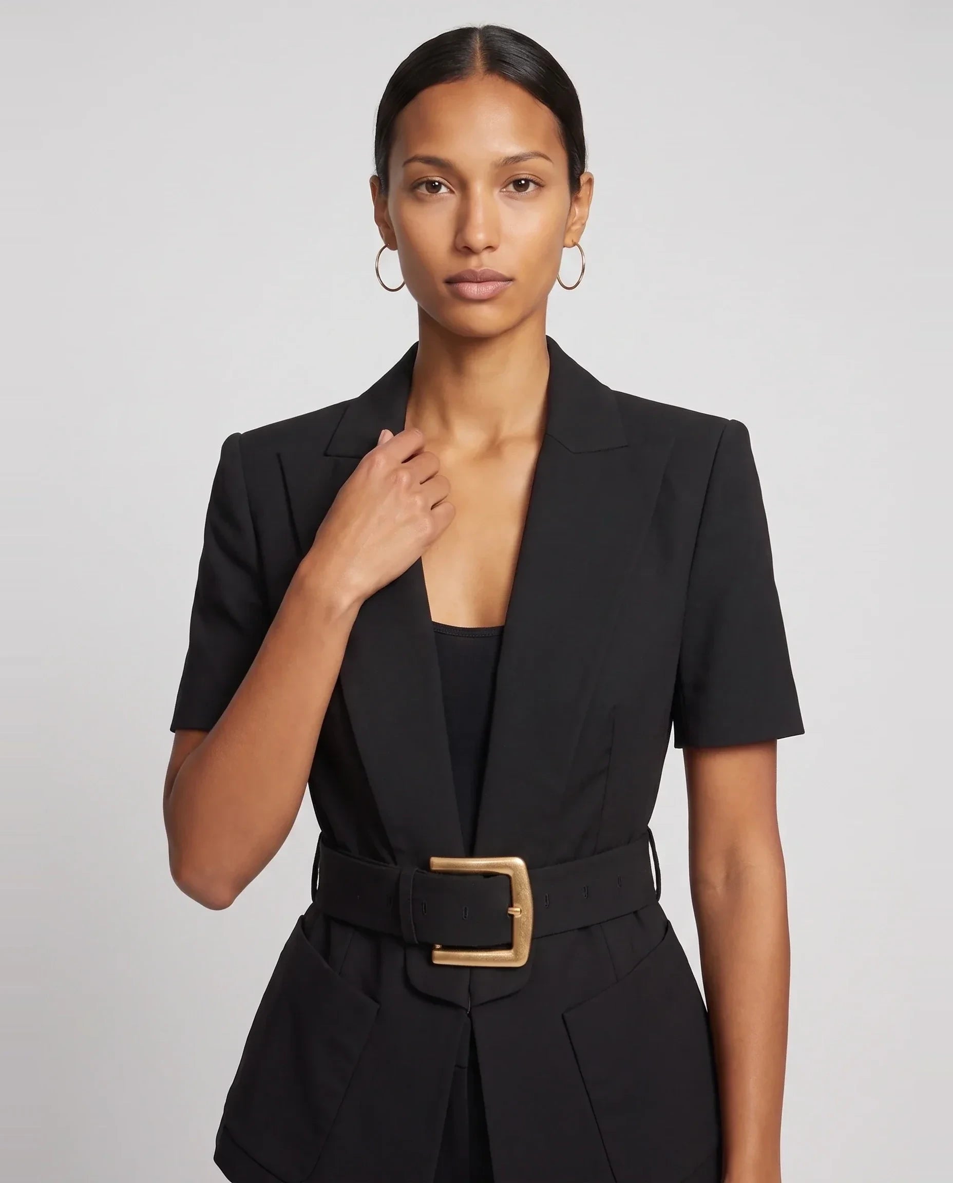 Veste cintrée ceinturée à manches courtes noire Aimée, plan rapproché en studio