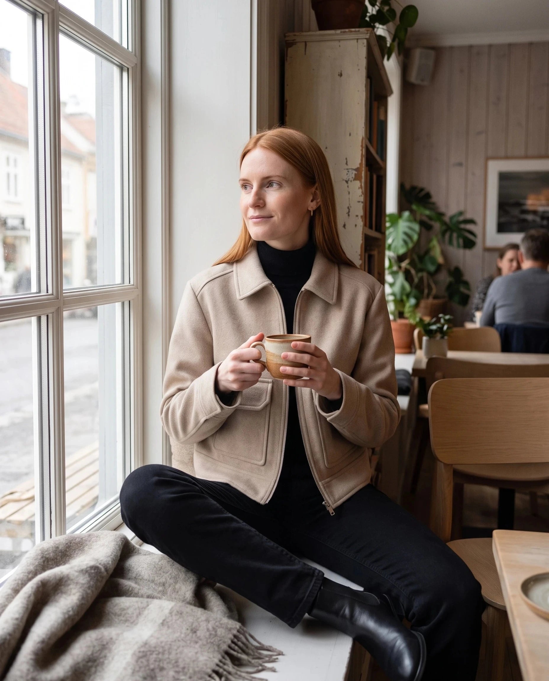Veste courte en lainage beige Solveig, portée dans un café scandinave