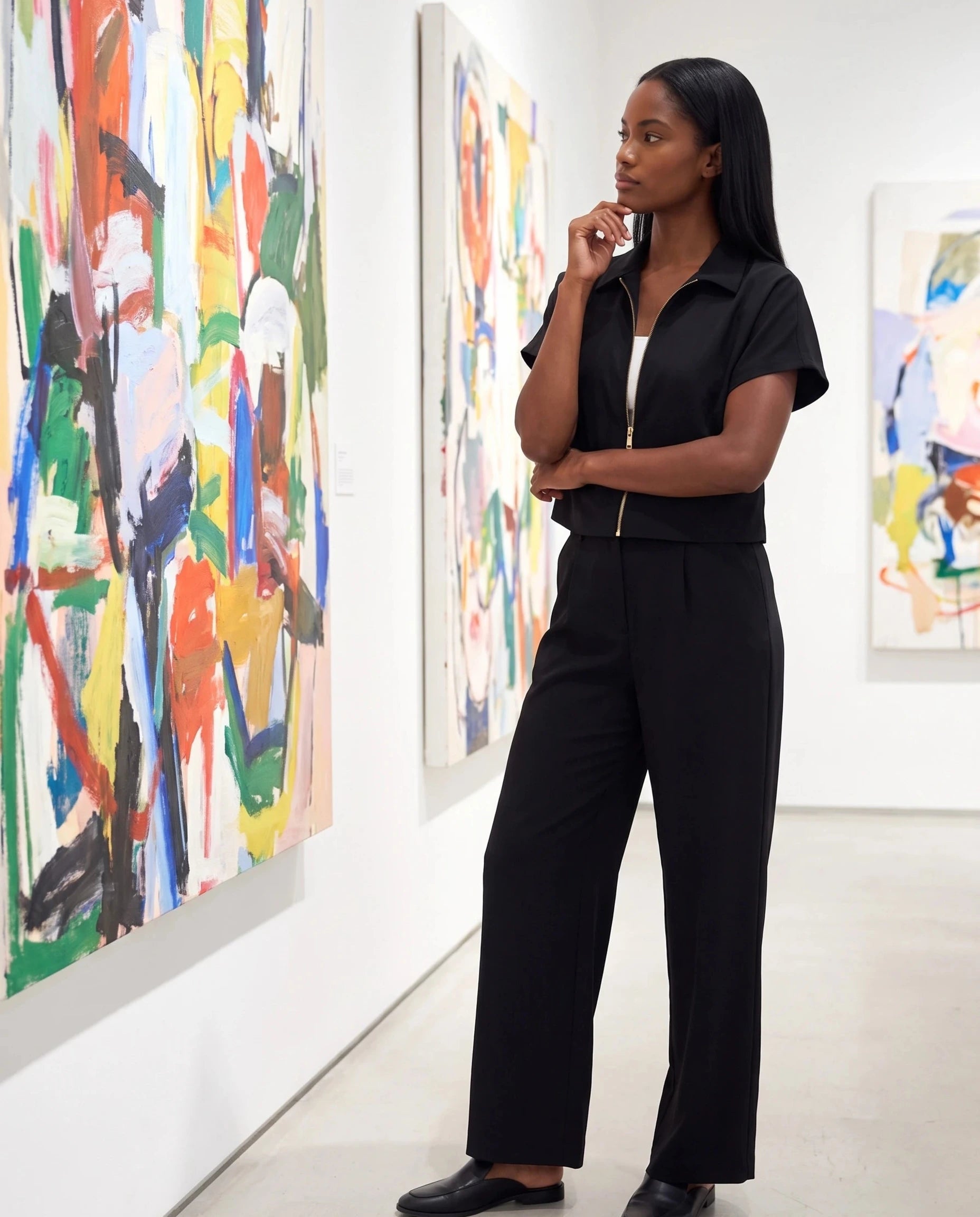 Veste courte zippée noire Gilberte, portée dans une galerie d'art moderne