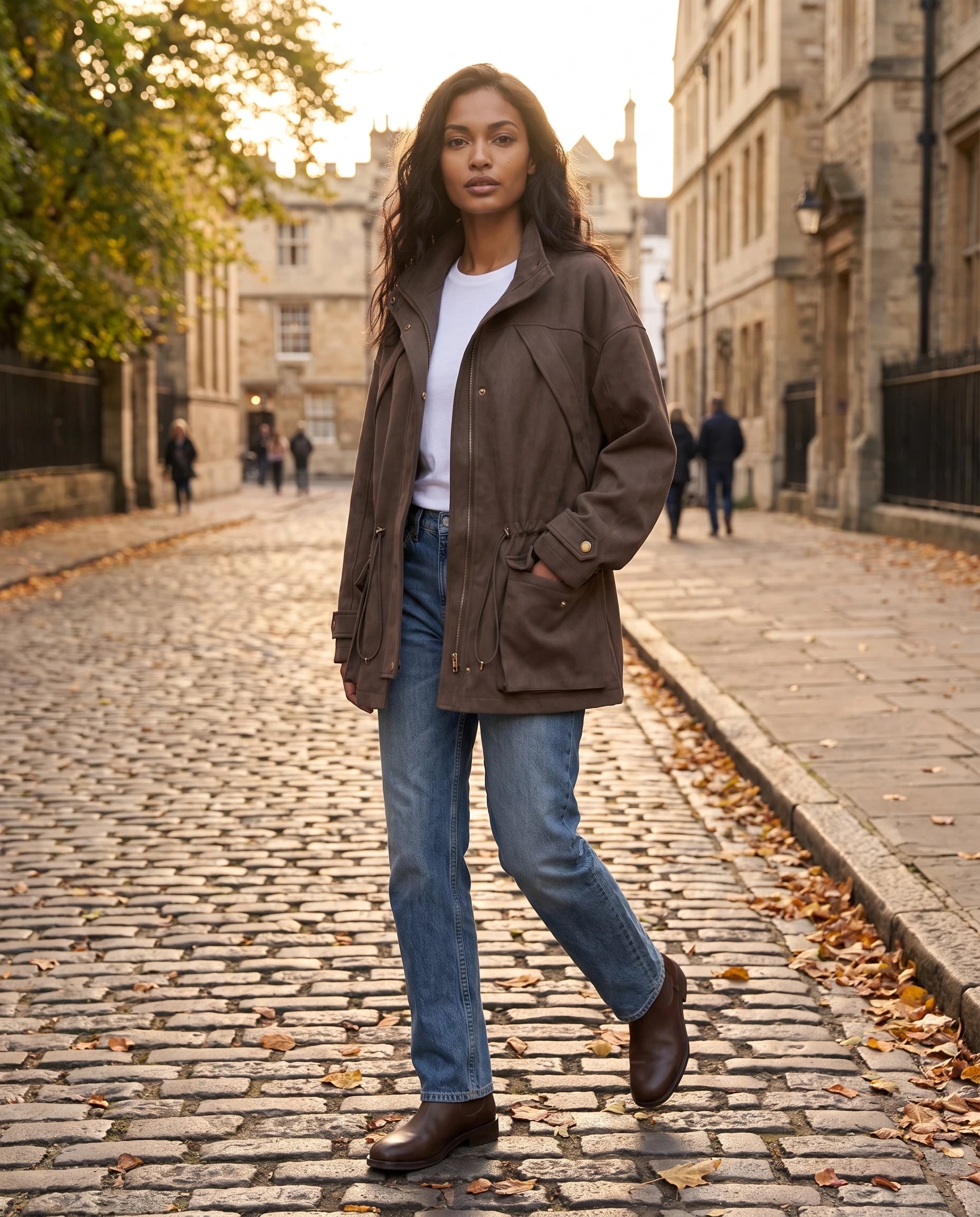 Veste mi-longue en suédine café Irène portée en rue pavée d'automne