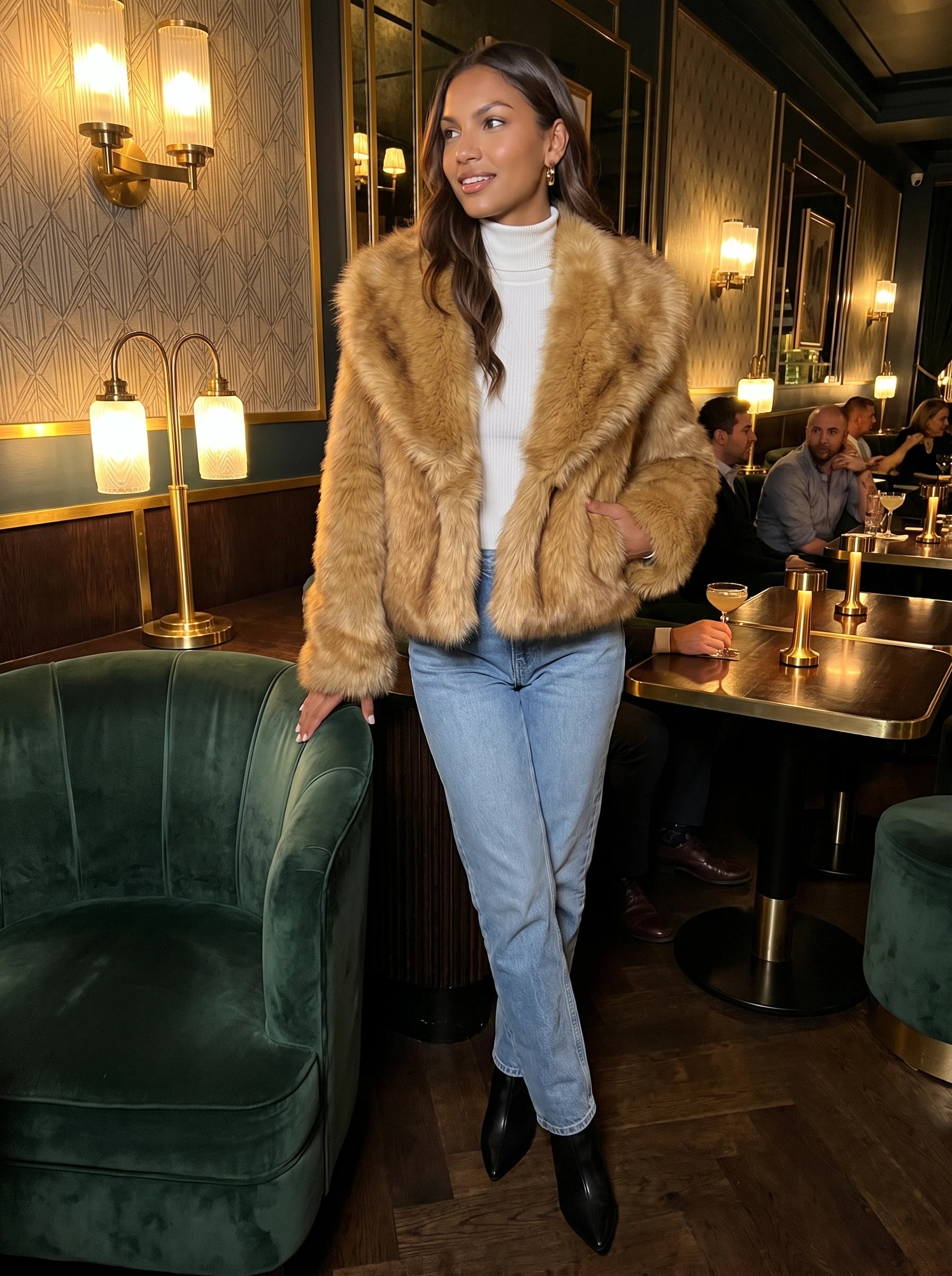 Veste fausse fourrure brun doré Nine, portée dans un bar art déco