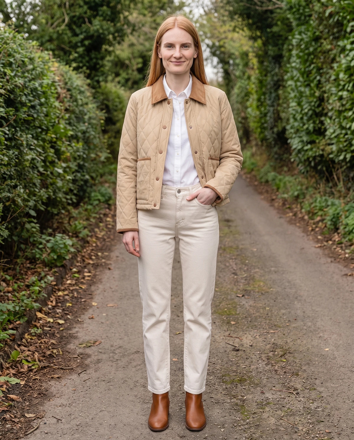 Veste matelassée courte à col velours côtelé Selma en Beige, portée sur un chemin de campagne bordé de haies, portée ouverte