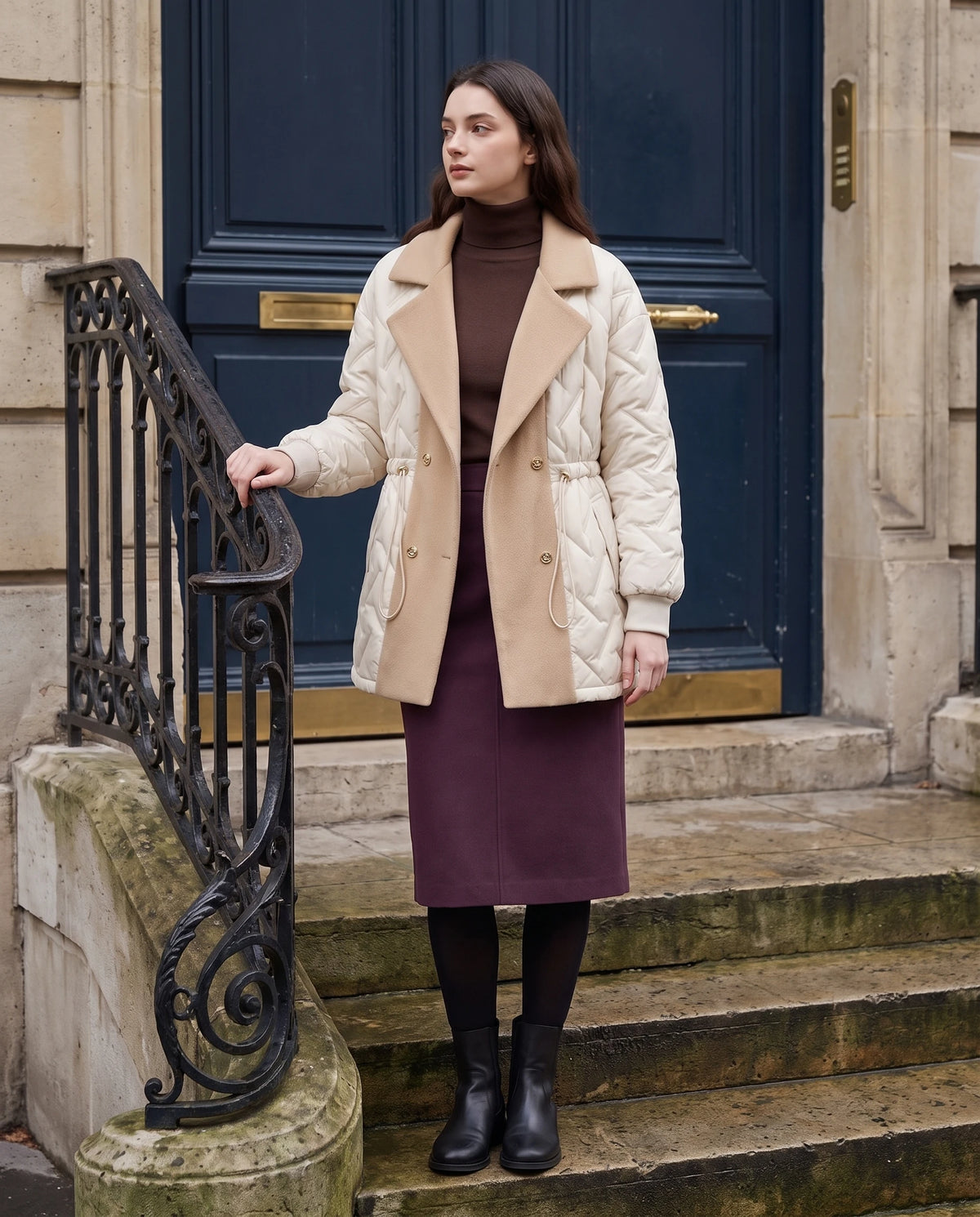 Veste matelassée mi-longue à grand col tailleur Géraldine en Écru, portée sur le perron d'un immeuble haussmannien