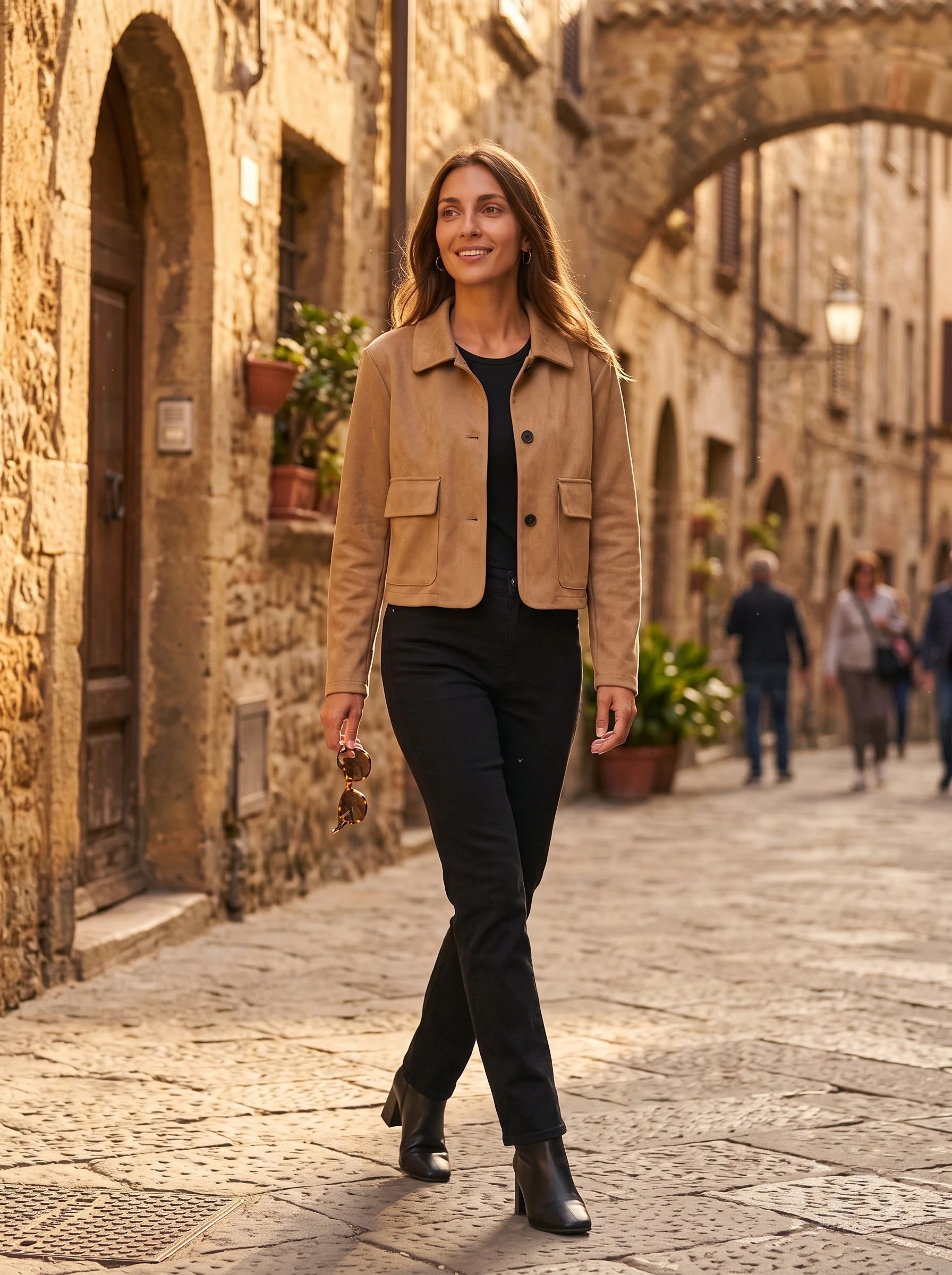 Veste en suédine camel Antonine, portée dans une vieille rue de pierre dorée
