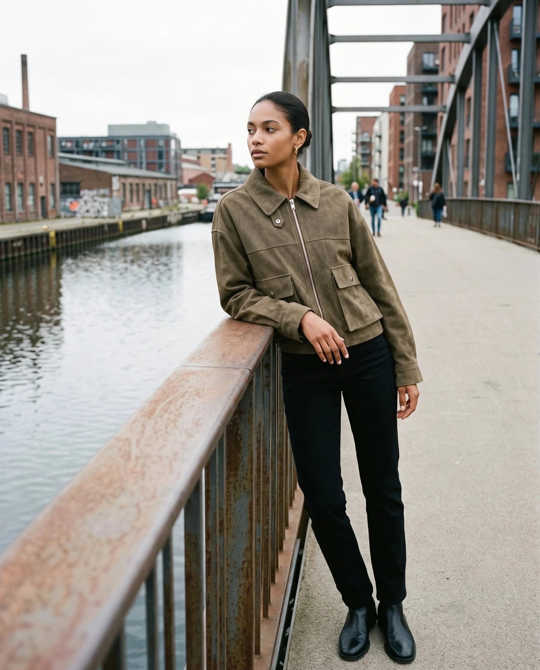 Veste utilitaire kaki Ernestine, portée sur une passerelle au-dessus d'un canal