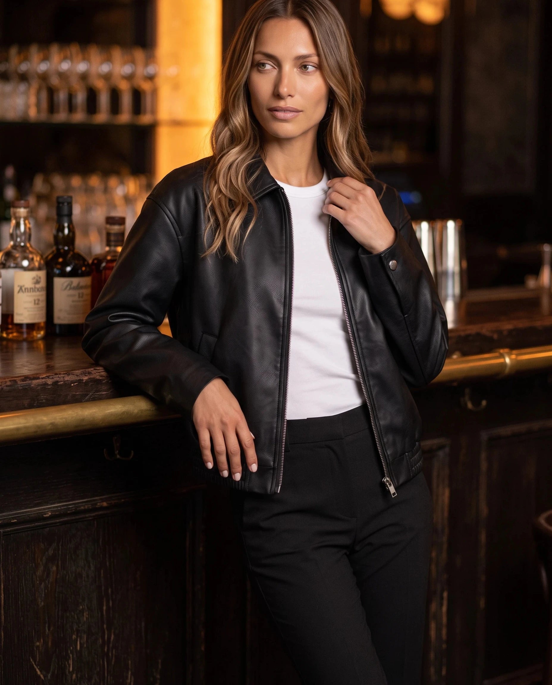 Veste effet cuir noir Louane, portée au comptoir d'un bar feutré