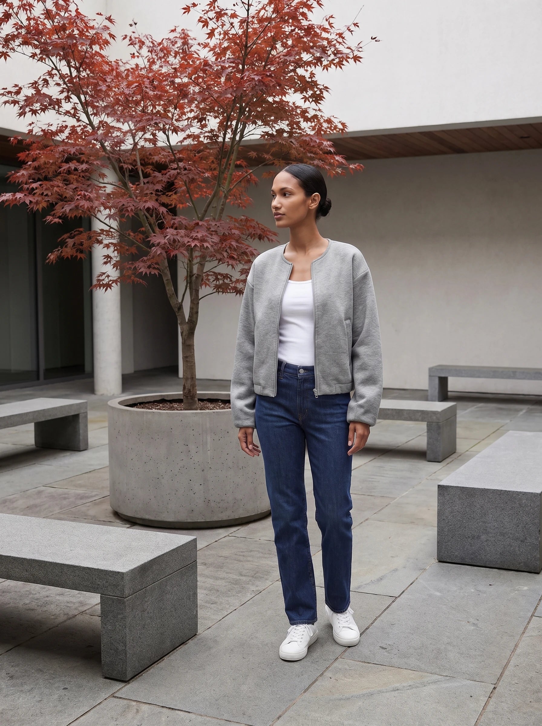 Veste zippée sans col gris chiné Germaine, portée dans une cour minérale à l'érable
