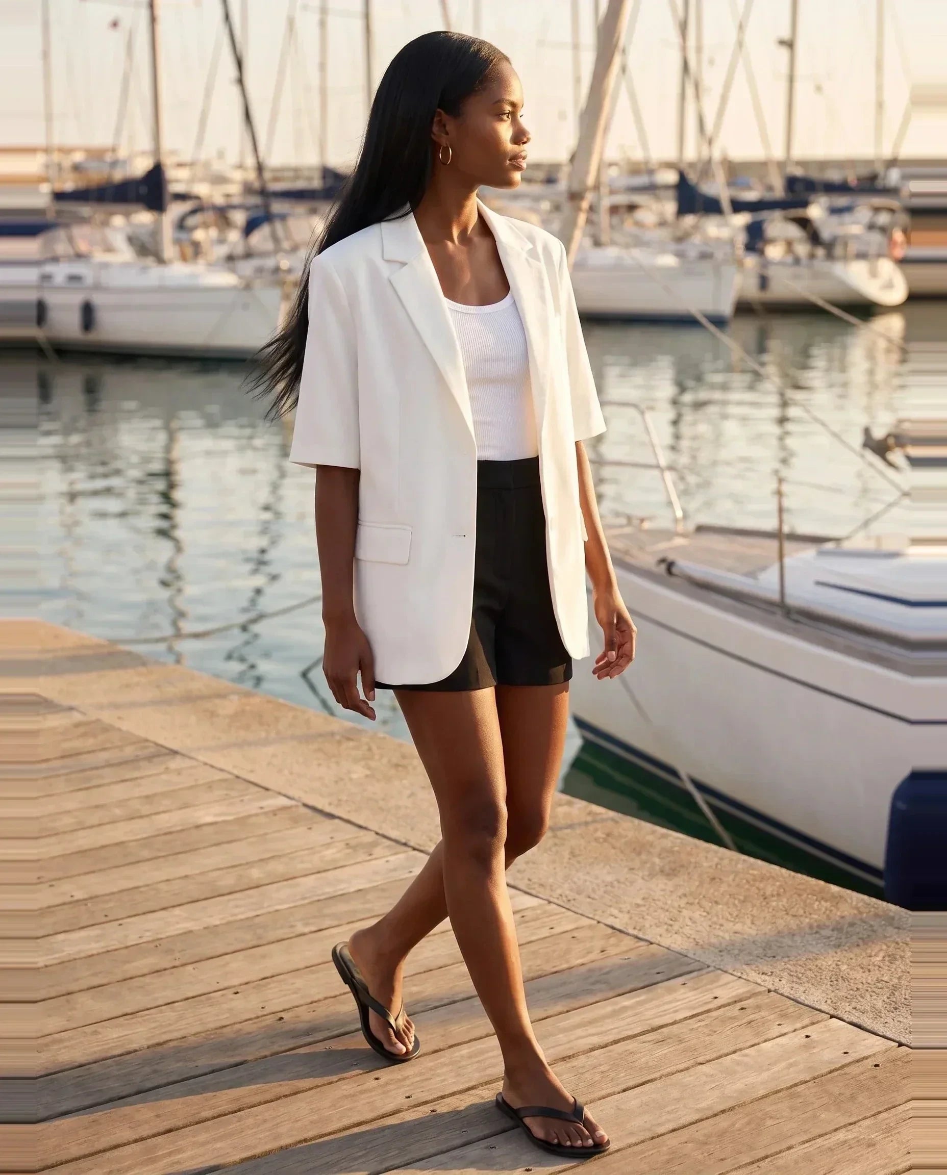 Blazer manches courtes blanc Arlette, porté le long d'une marina en fin d'après-midi