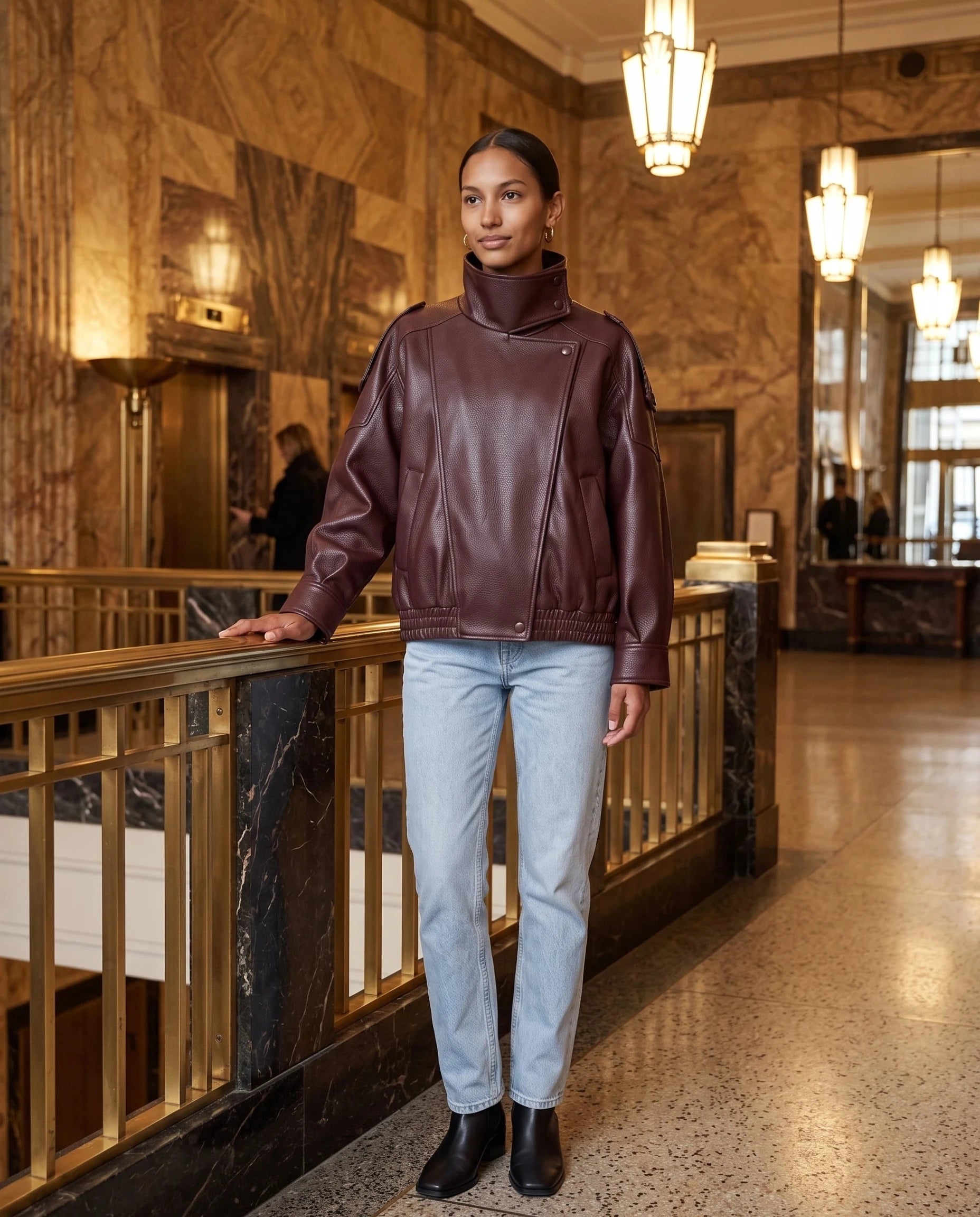 Blouson effet cuir bordeaux Léocadie, porté dans un hall art déco