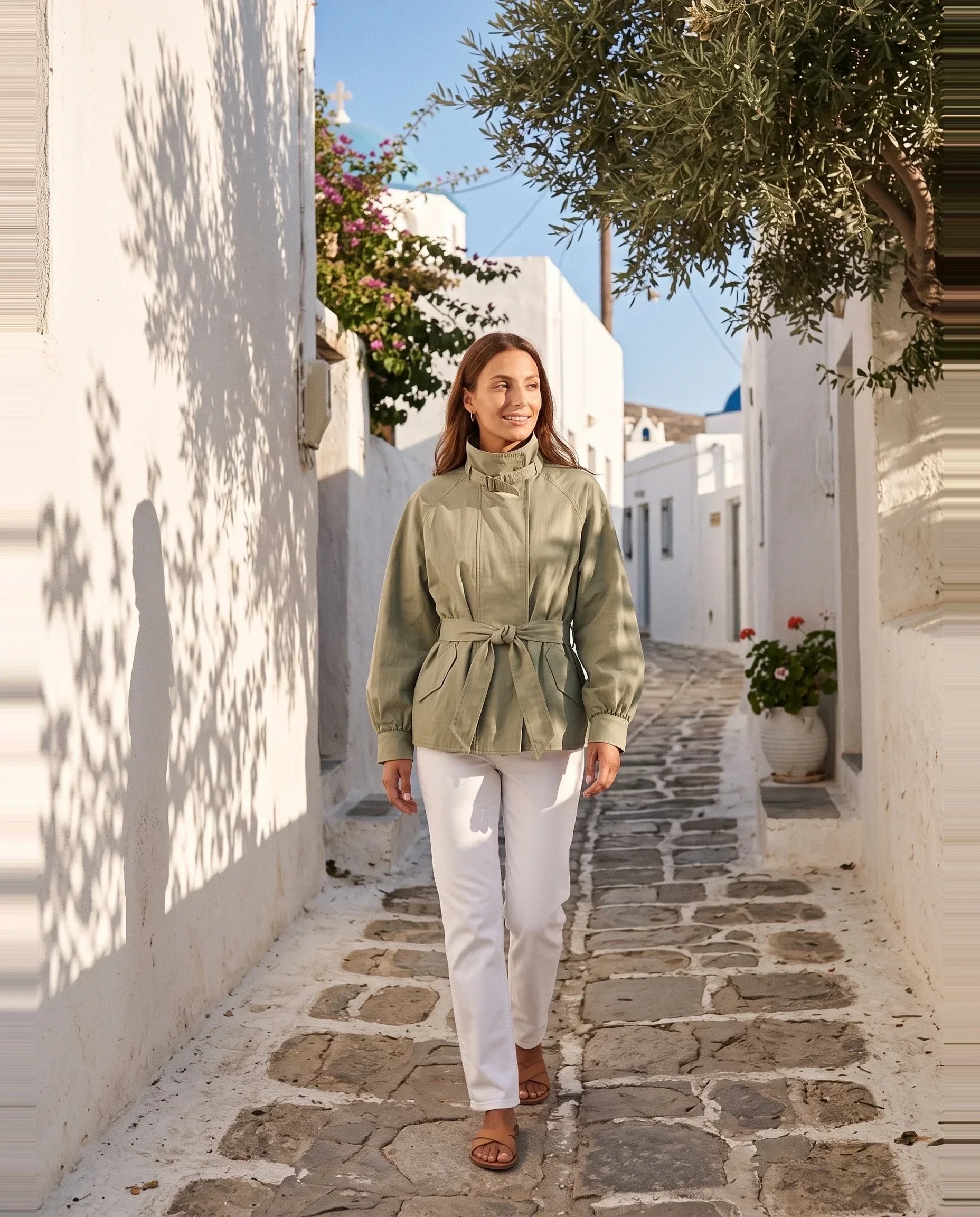 Blouson fluide vert sauge Charline, porté dans une ruelle blanchie ensoleillée