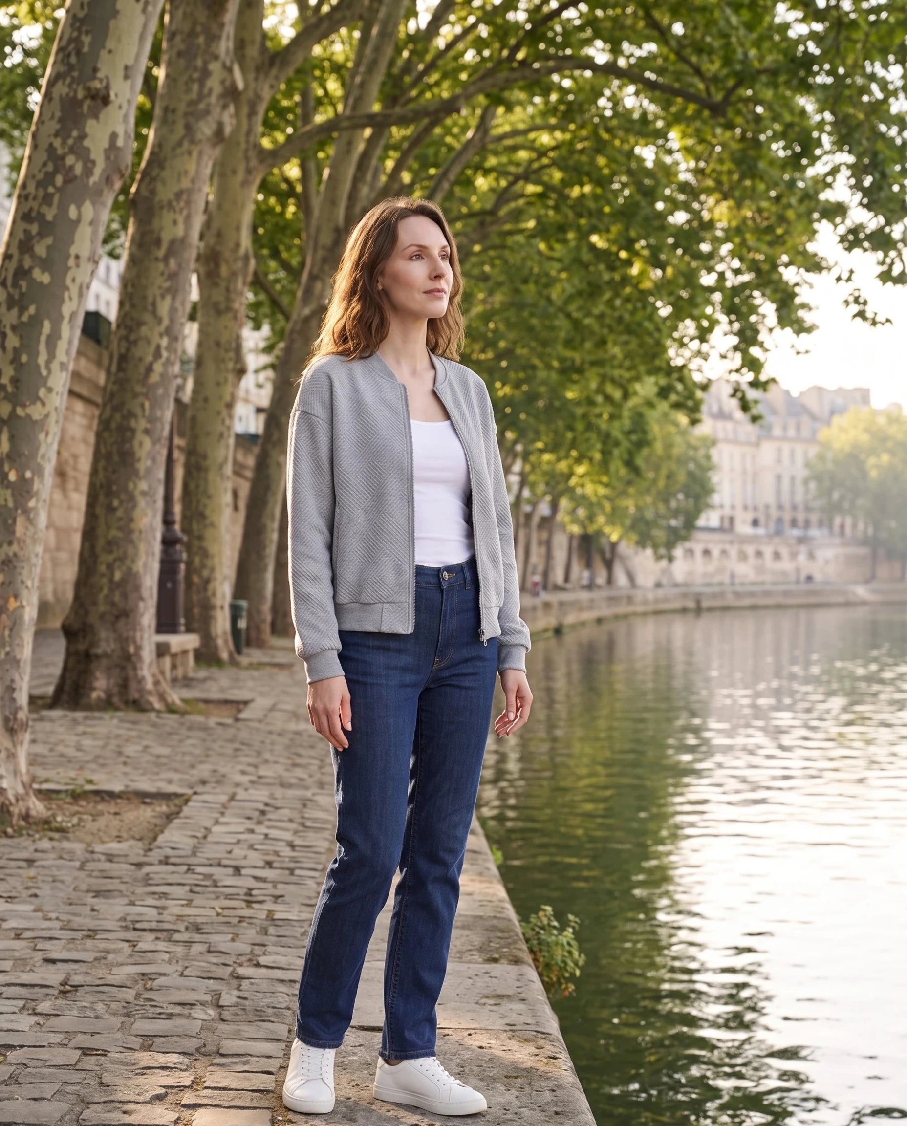 Bomber en jersey texturé gris chiné Rolande, porté sur un quai de rivière sous les platanes