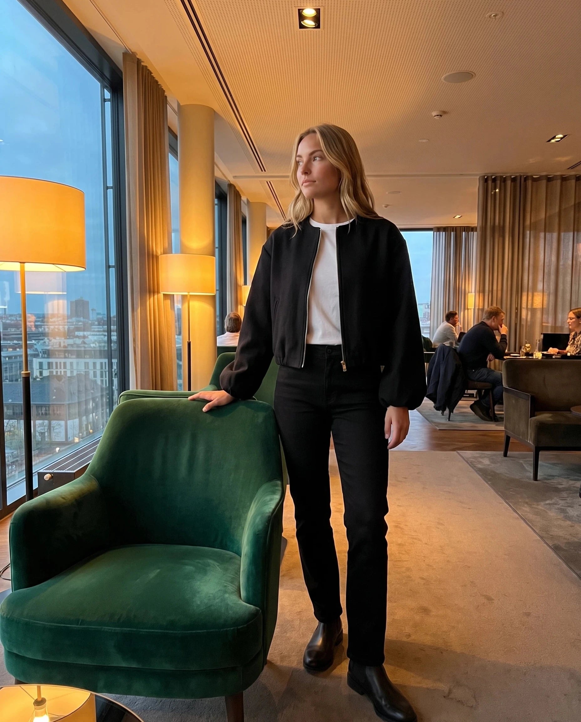 Bomber lainage noir Ambroisine, porté dans le lounge d'un hôtel