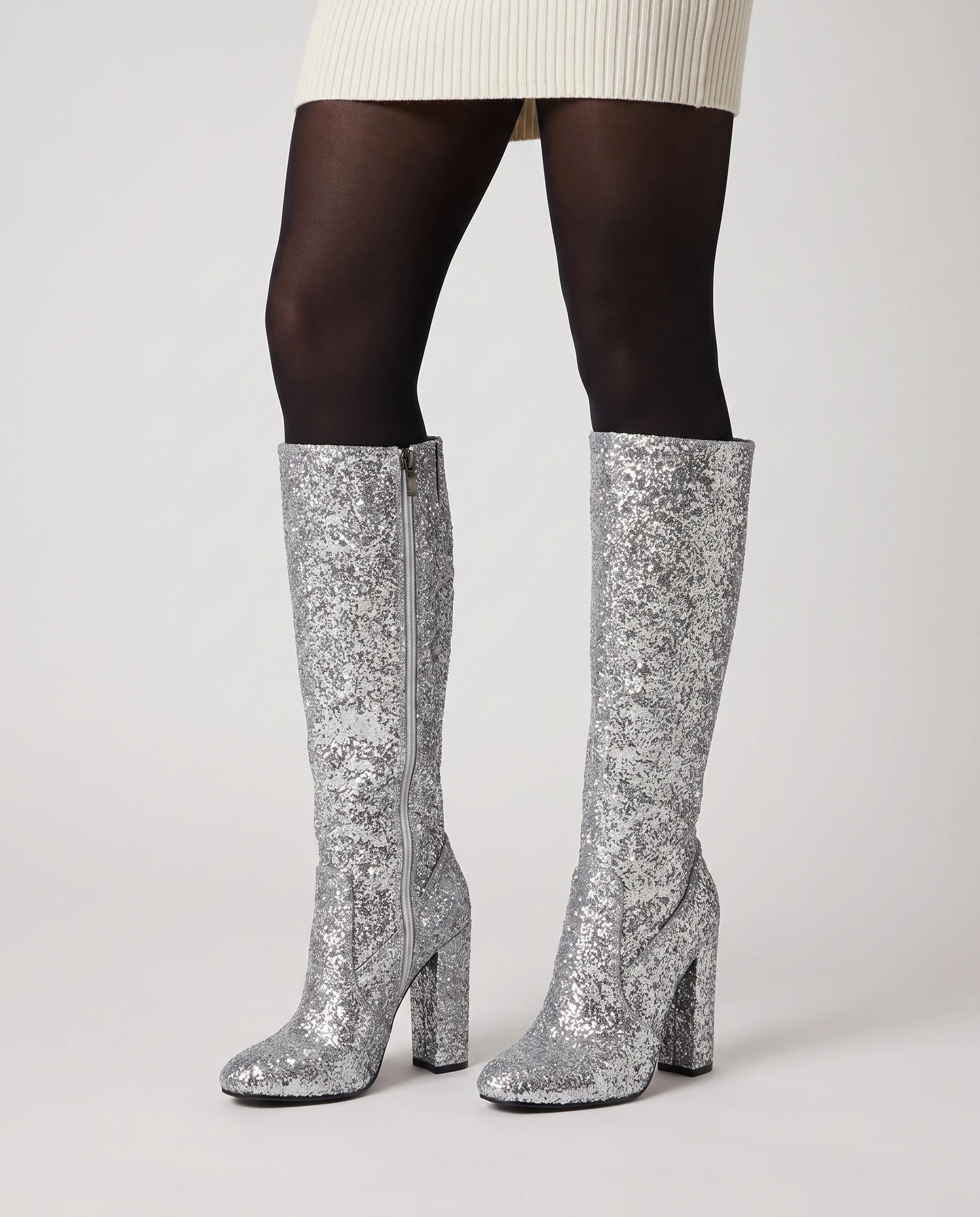 Bottes hautes à paillettes à talon large Éliette — Argent, portées en plan rapproché avec des collants opaques