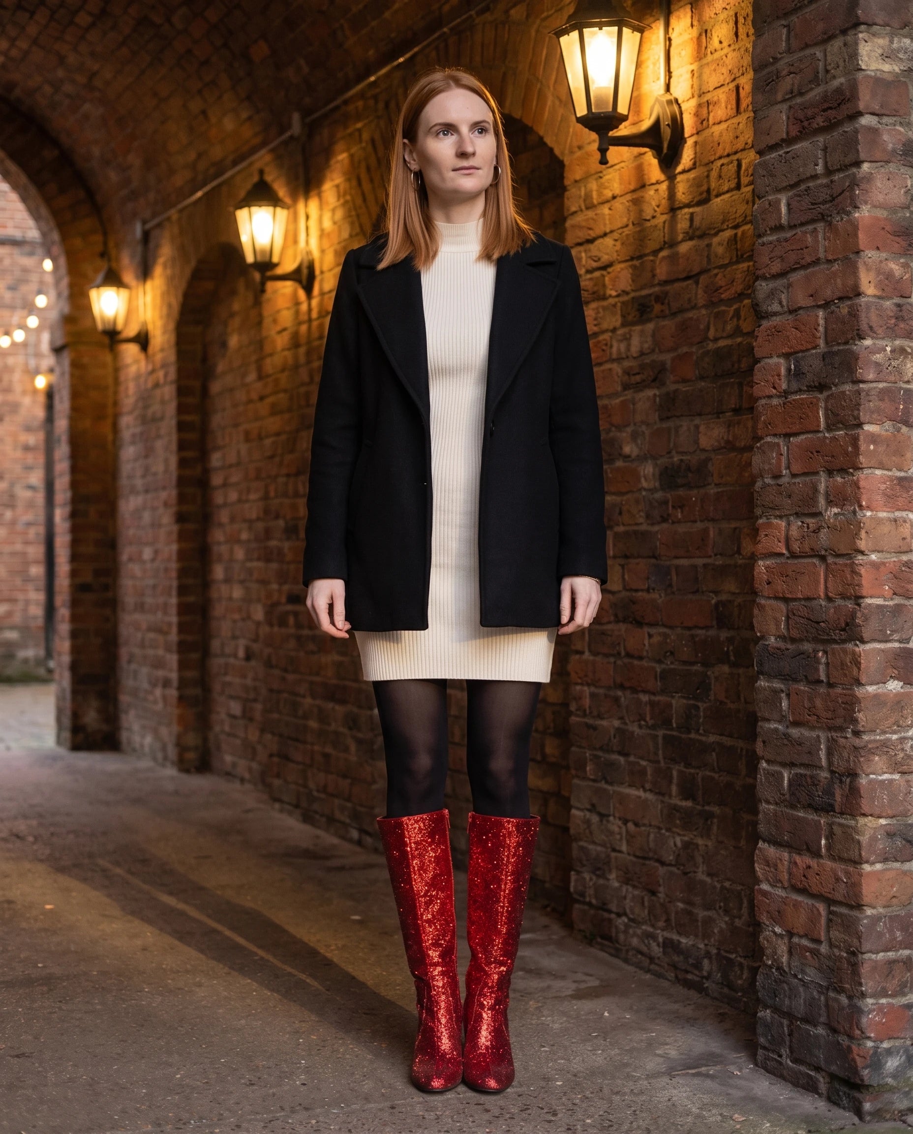 Bottes hautes à paillettes à talon large Éliette — Rouge, portées sous une arche de brique éclairée