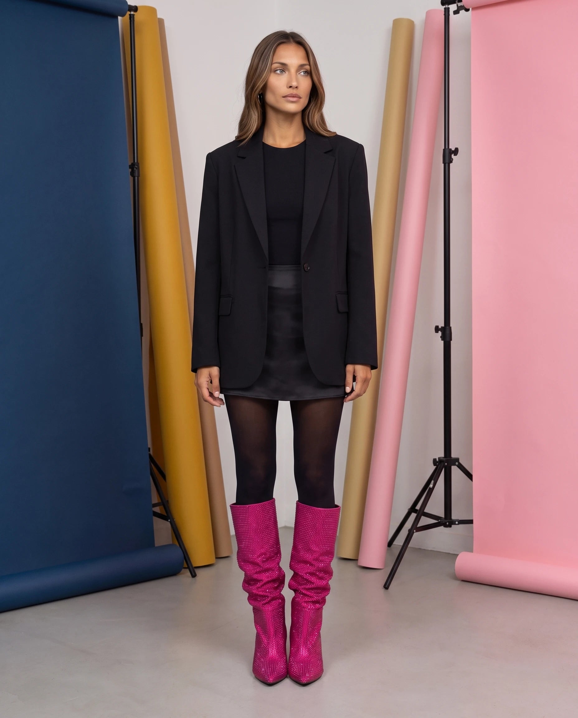 Bottes hautes slouchy à strass Odalie — Fuchsia, portées dans un studio photo aux fonds colorés