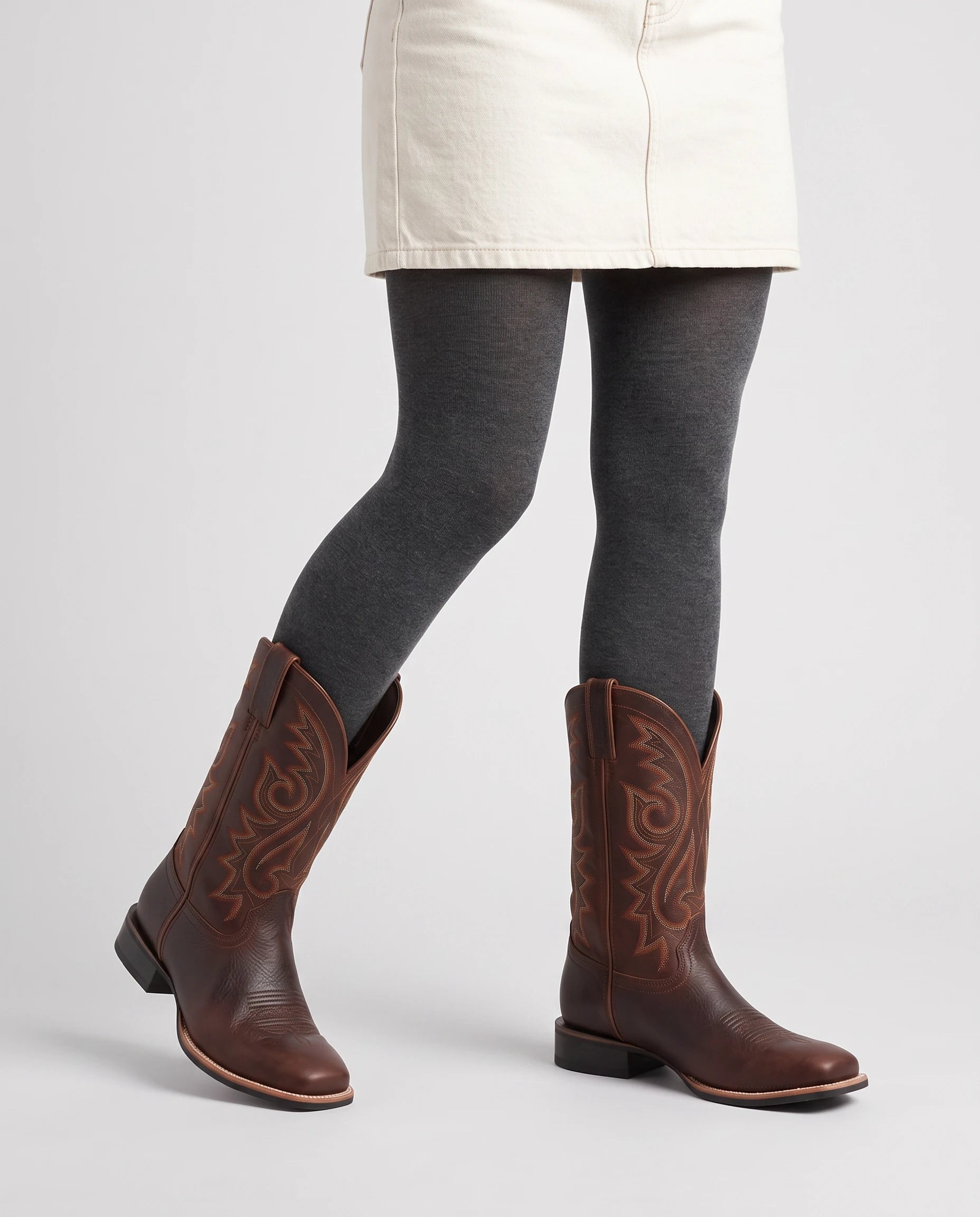 Bottes western à bout rond Marion — Chocolat, portées en plan rapproché, un pied avancé