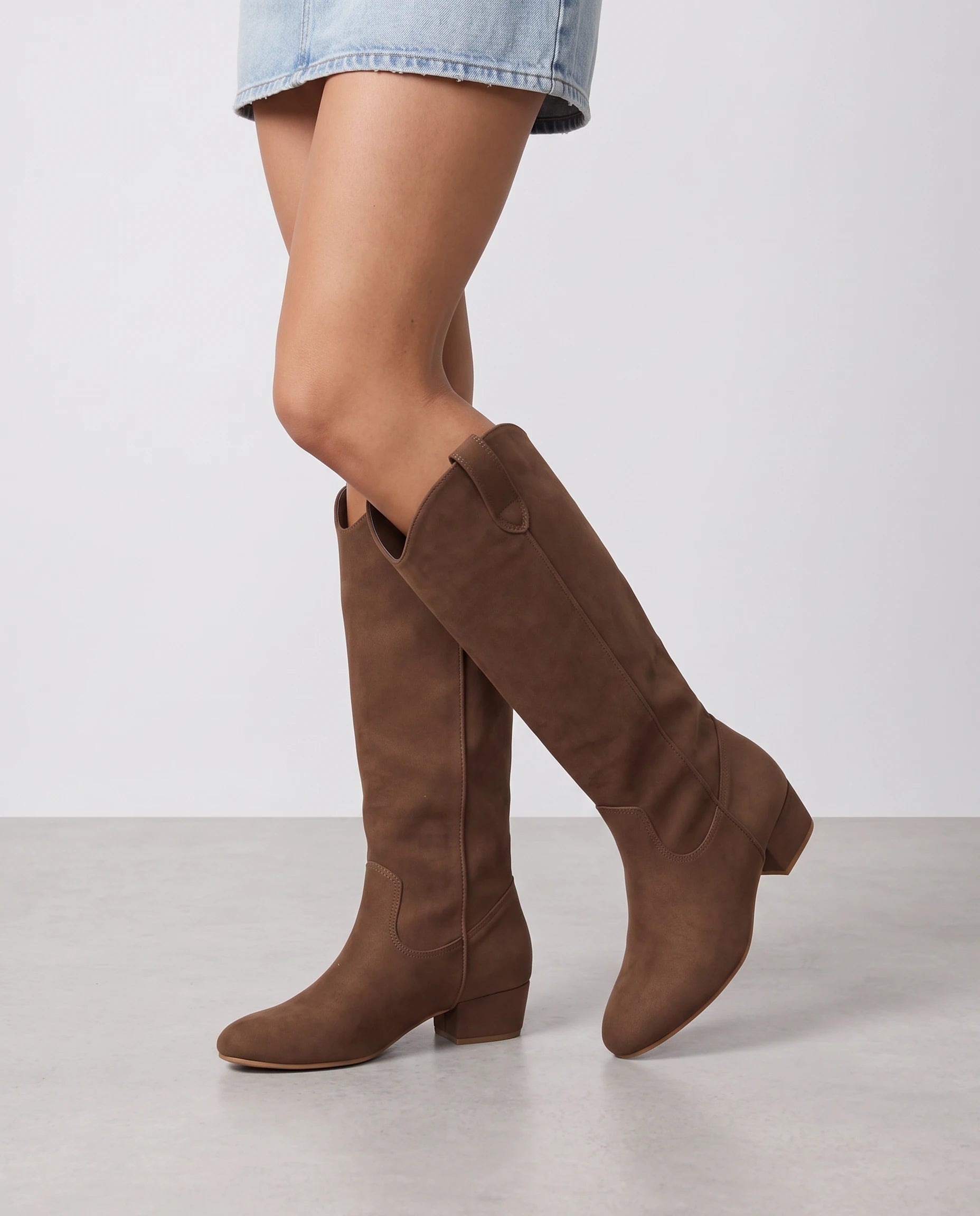 Bottes hautes western en suédine Marjolaine — Chocolat, portées en plan rapproché de trois quarts