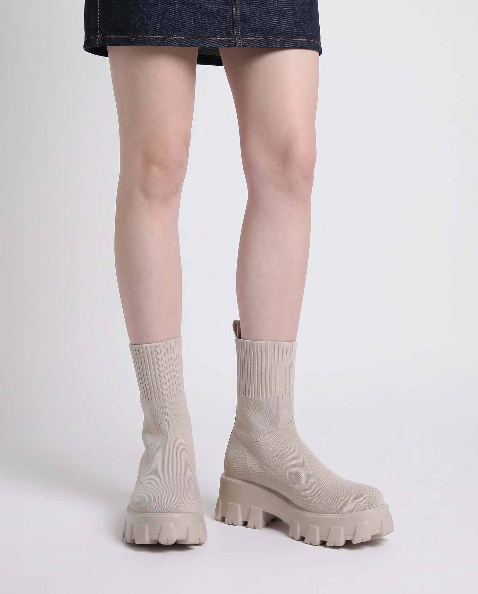 Bottines chaussettes à plateforme Antoinette — Beige, portées en plan rapproché avec une jupe en jean