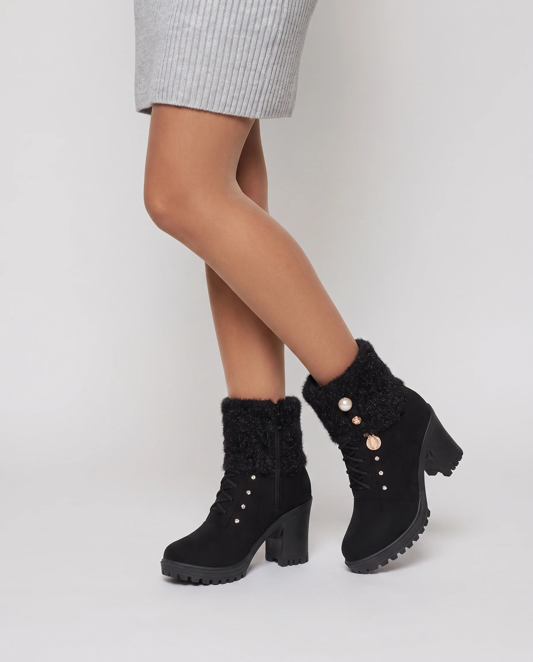 Bottines fourrées à talon et revers en maille Lucrèce — Noir, portées en plan rapproché, genou fléchi