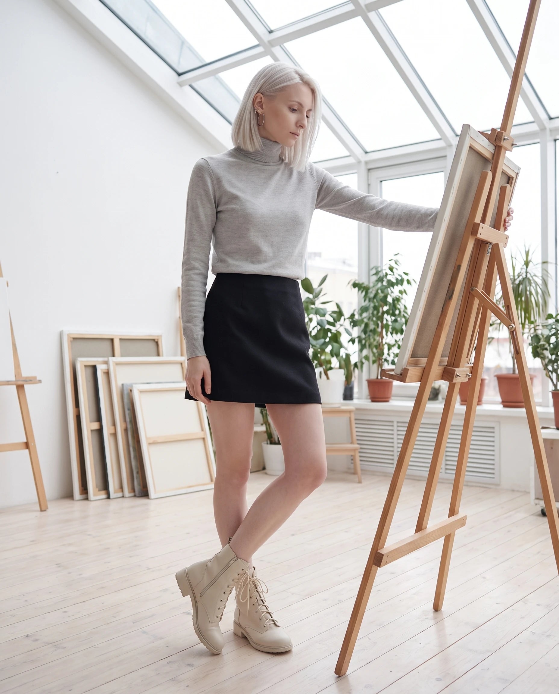 Bottines à lacets à talon effet cuir Alphonsine — Blanc Cassé, portées dans un atelier d'artiste sous verrière