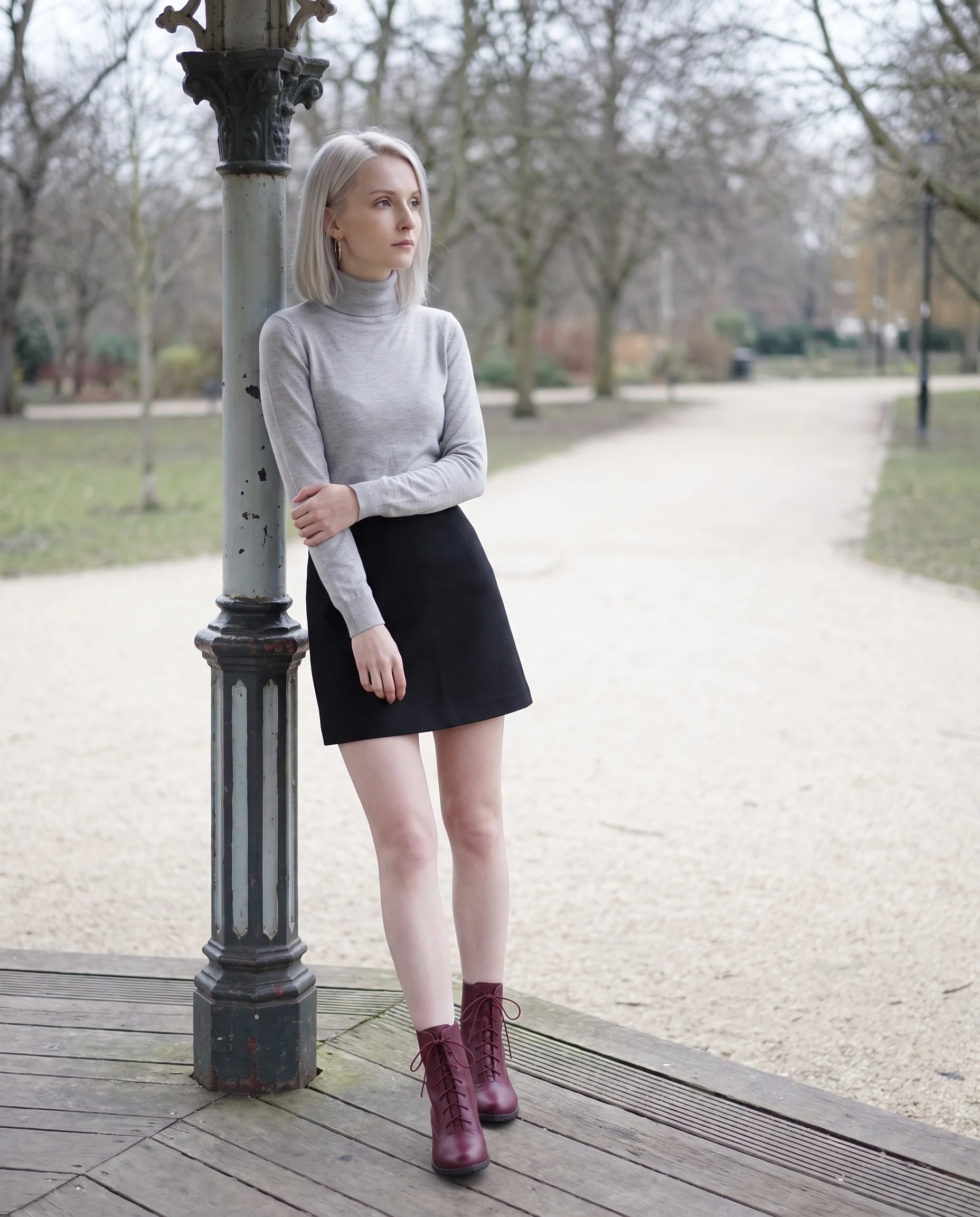 Bottines à lacets à talon effet cuir Alphonsine — Bordeaux, portées près d'un kiosque à musique dans un parc en hiver