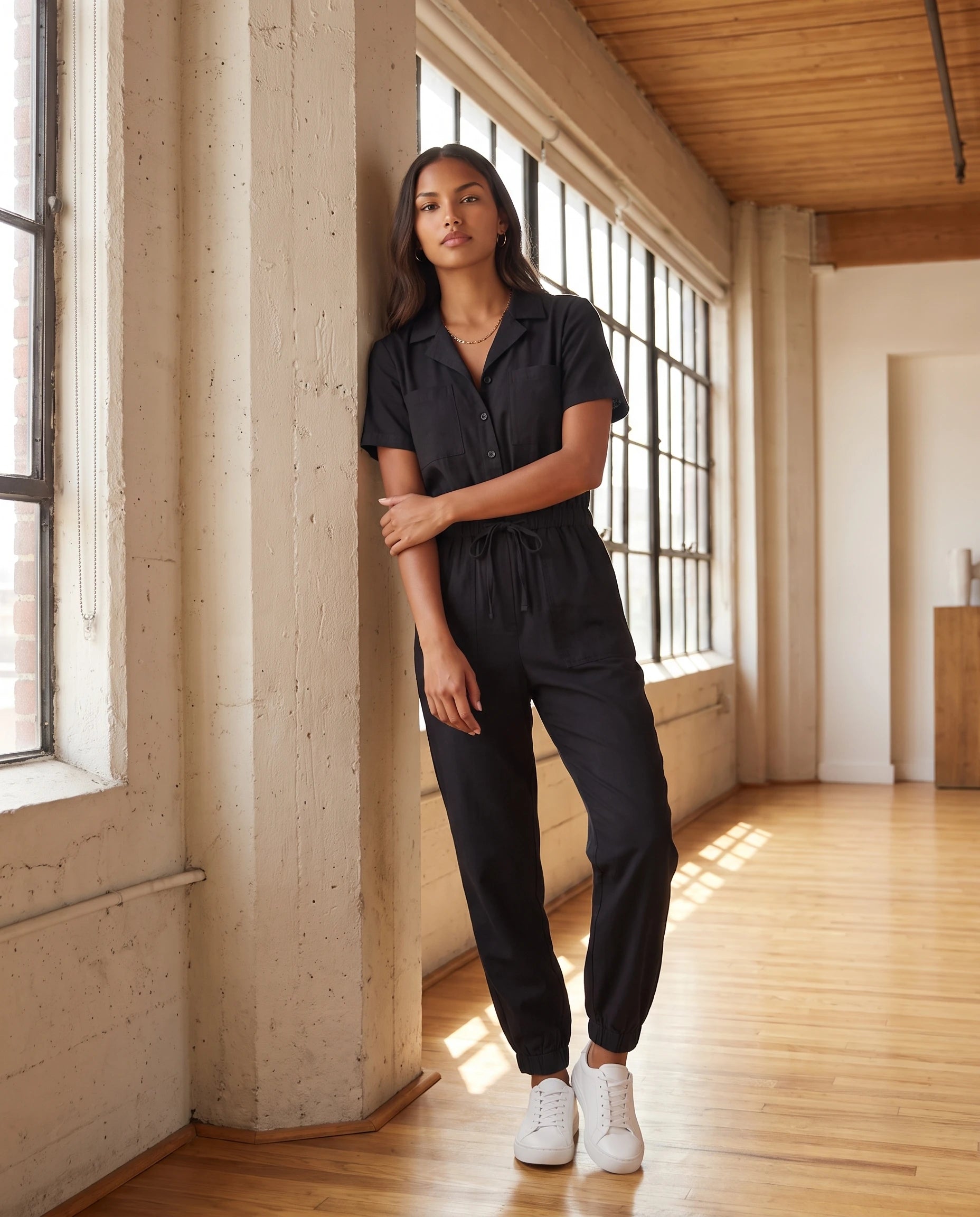 Combinaison cargo boutonnee Marceline en Noir, dans un loft industriel
