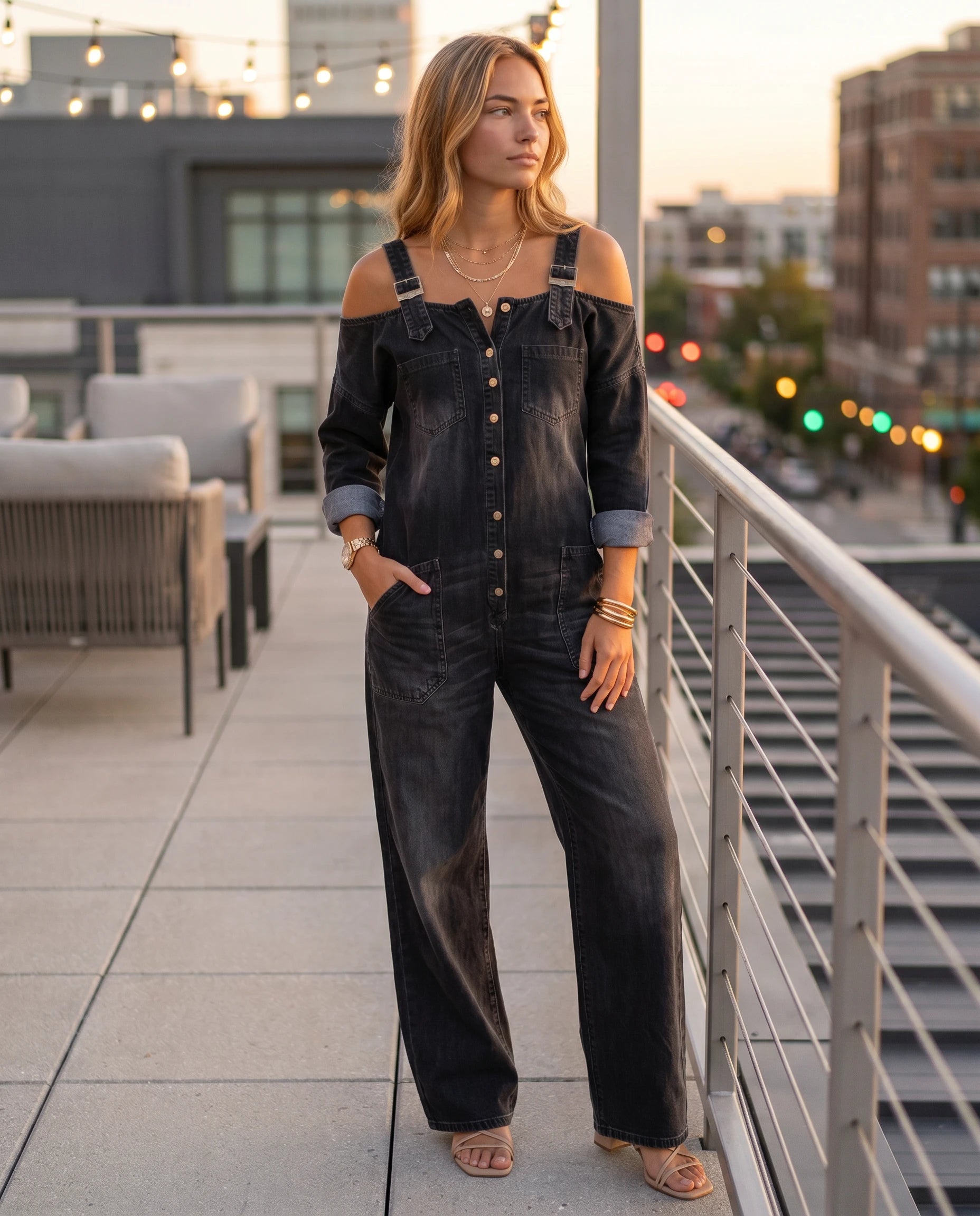 Combinaison en jean à épaules dénudées Maëlys — Noir, portée sur un rooftop au crépuscule