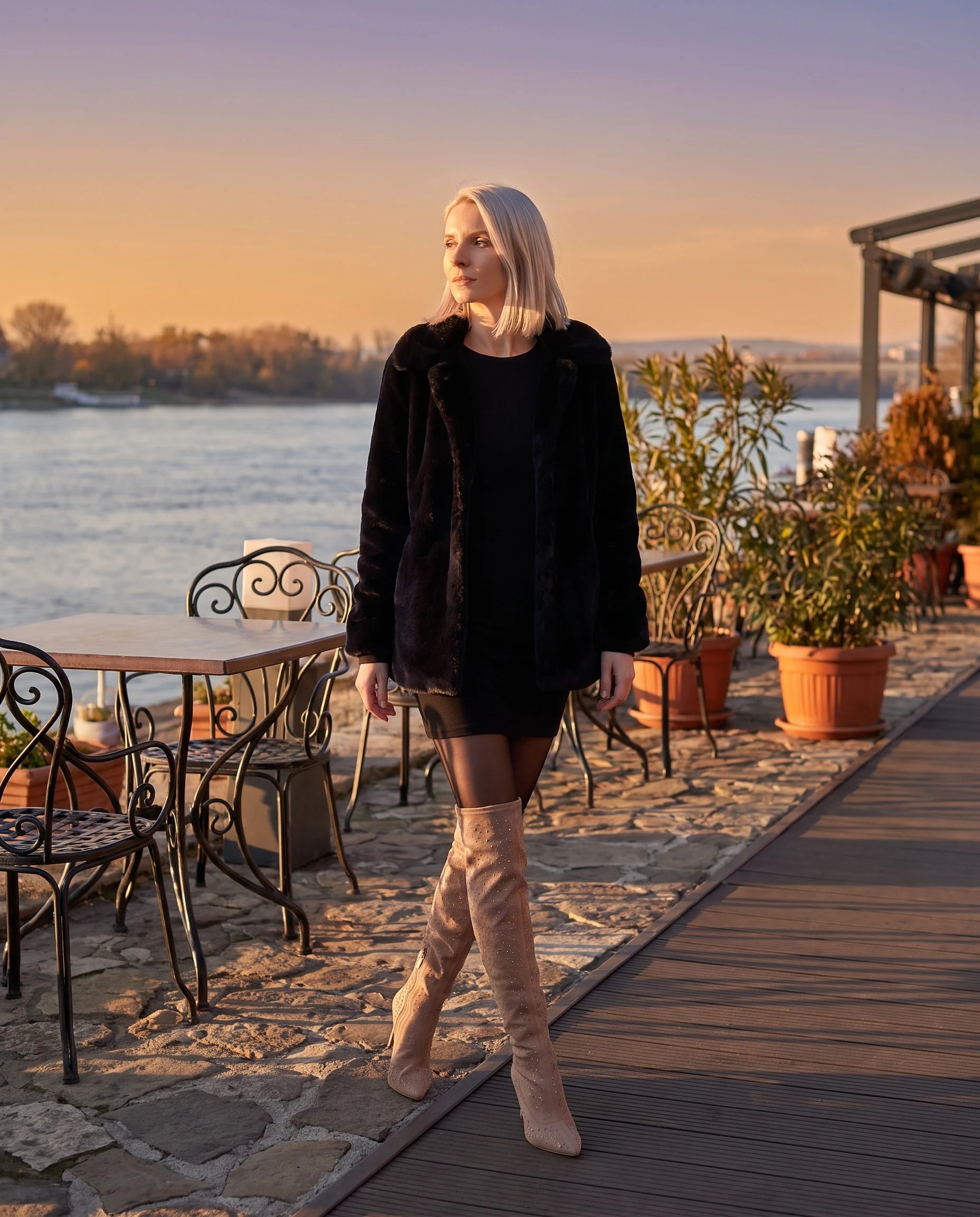Cuissardes en suédine à strass Bérangère — Grège, portées sur une terrasse au bord d'un fleuve à l'heure dorée