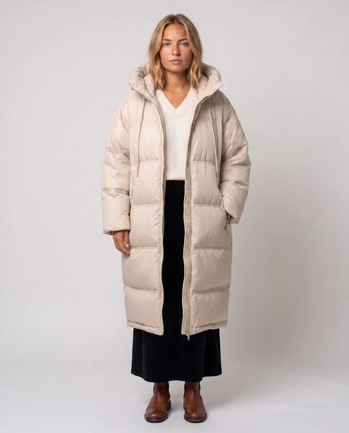 Extralanger Kokon-Steppmantel mit Kordelkapuze Pascale in Hellbeige, offen getragen über cremefarbenem Pullover, Reissverschluss offen