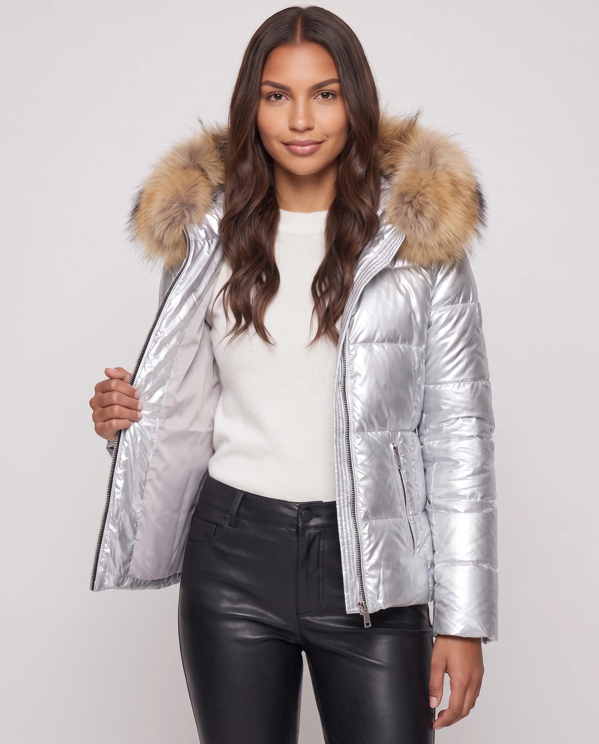 Kurze glänzende Steppjacke mit Kunstfellkapuze Victoria in Silber, offen getragen über weissem Pullover