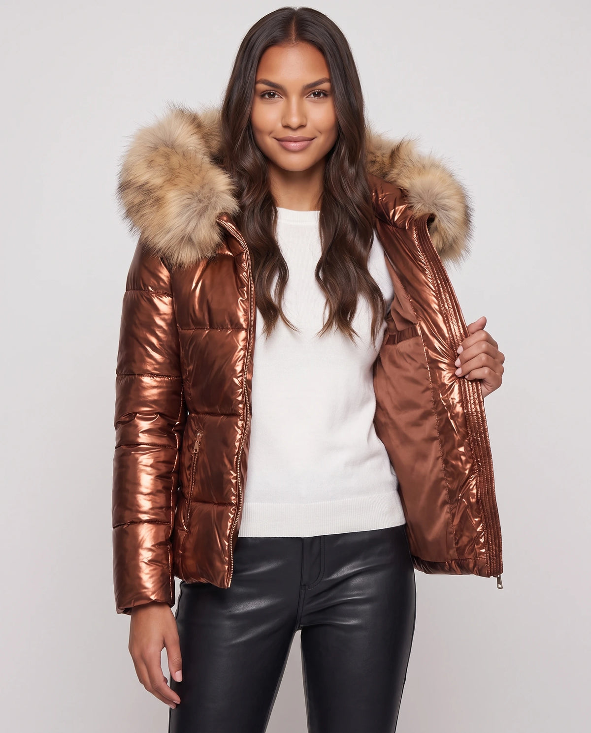 Kurze glänzende Steppjacke mit Kunstfellkapuze Victoria in Kupfer, offen getragen über weissem Pullover