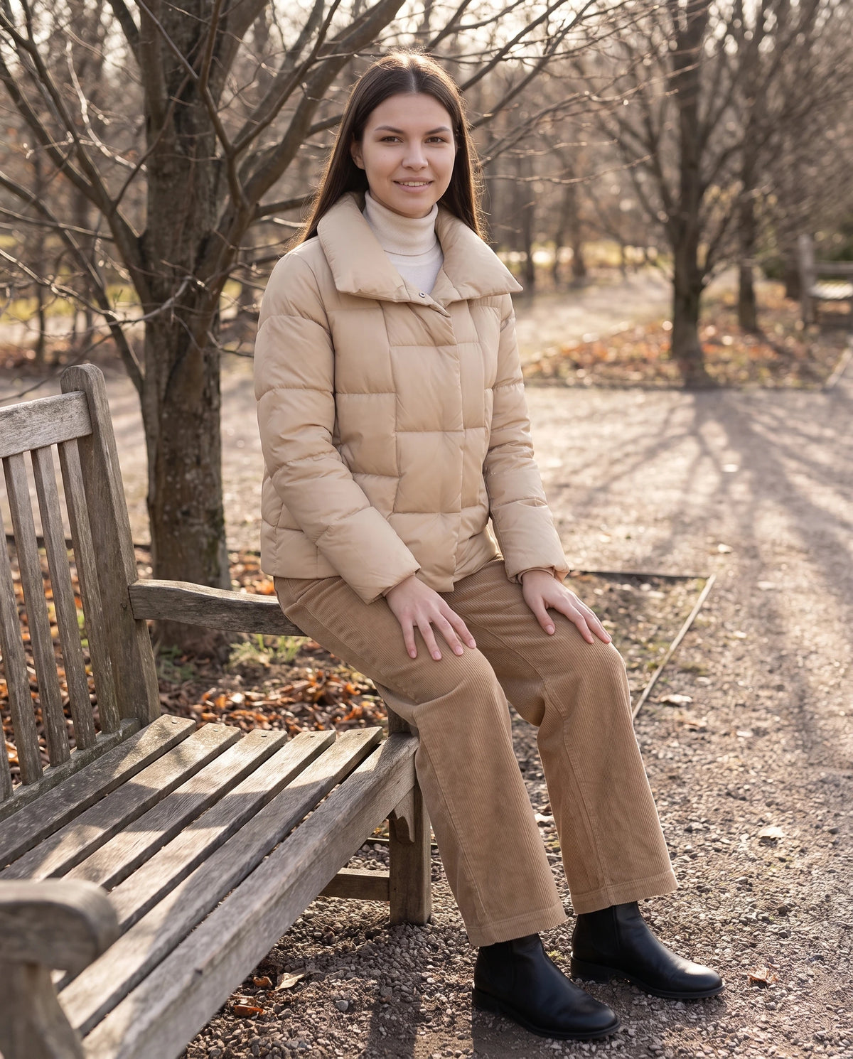 Kurze Steppjacke mit grossem Kragen und grossen Karos Stéphanie in Beige, getragen auf einer Parkbank sitzend