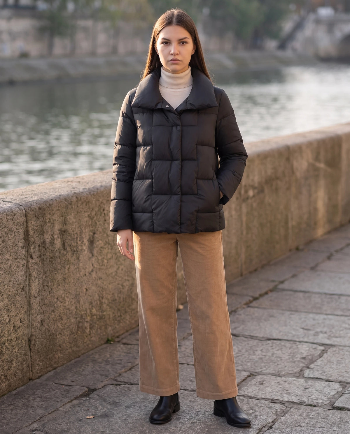 Kurze Steppjacke mit grossem Kragen und grossen Karos Stéphanie in Schwarz, getragen auf einem Kai am Fluss