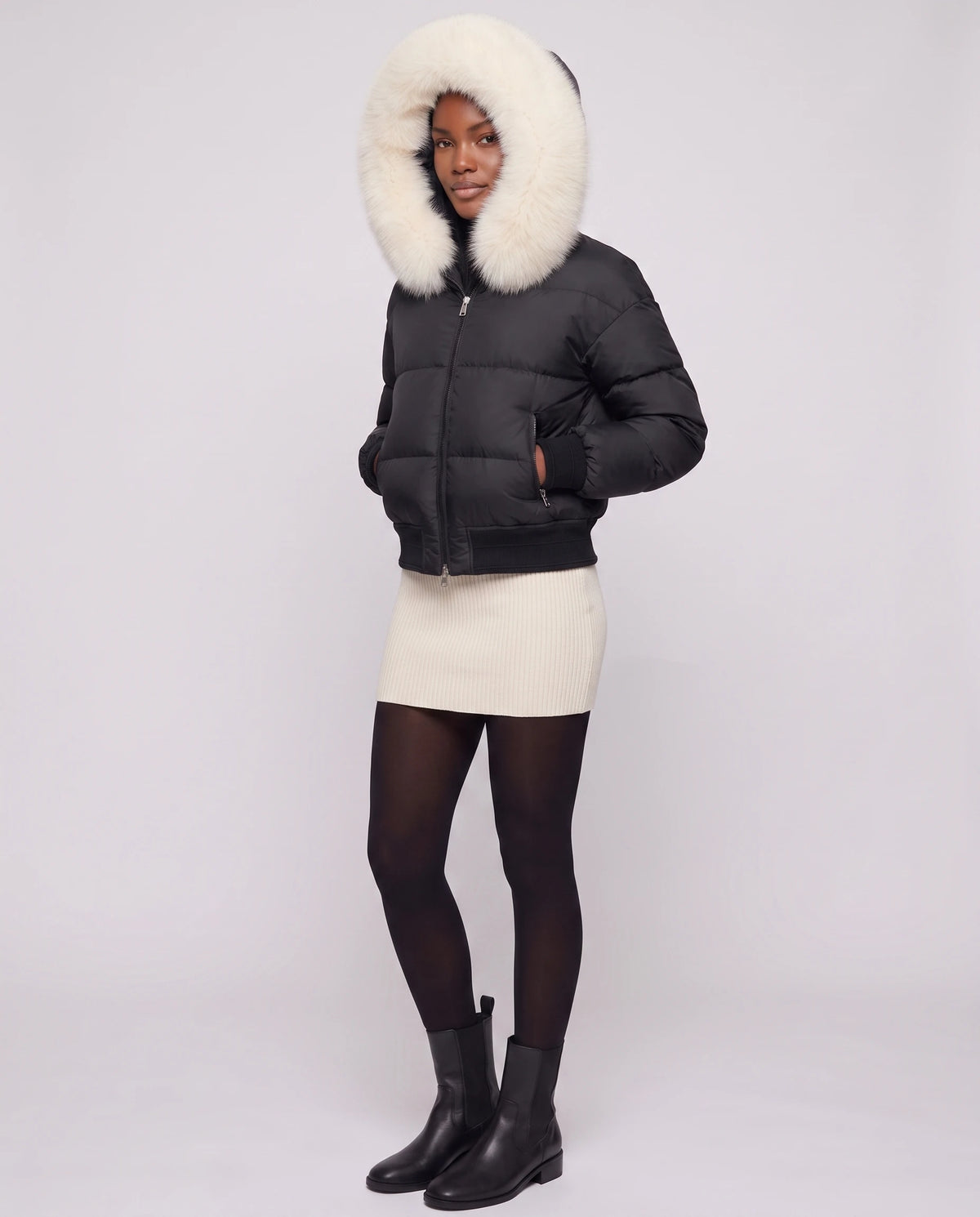 Kurze Steppjacke mit grosser Kunstfellkapuze Rebecca in Schwarz · weisses Fell, Dreiviertelansicht, grosse Kunstfellkapuze aufgesetzt