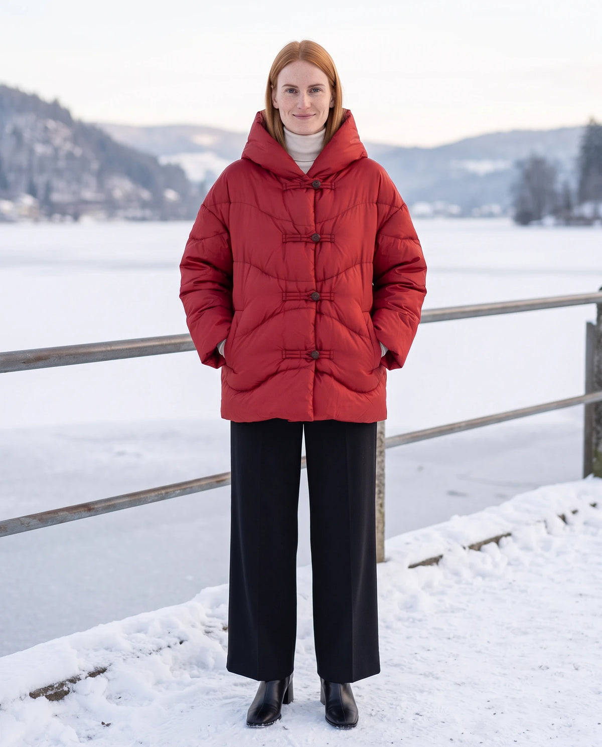 Doudoune courte oversize à capuche et brandebourgs Andréa en Rouge, portée sur une promenade enneigée au bord d'un lac