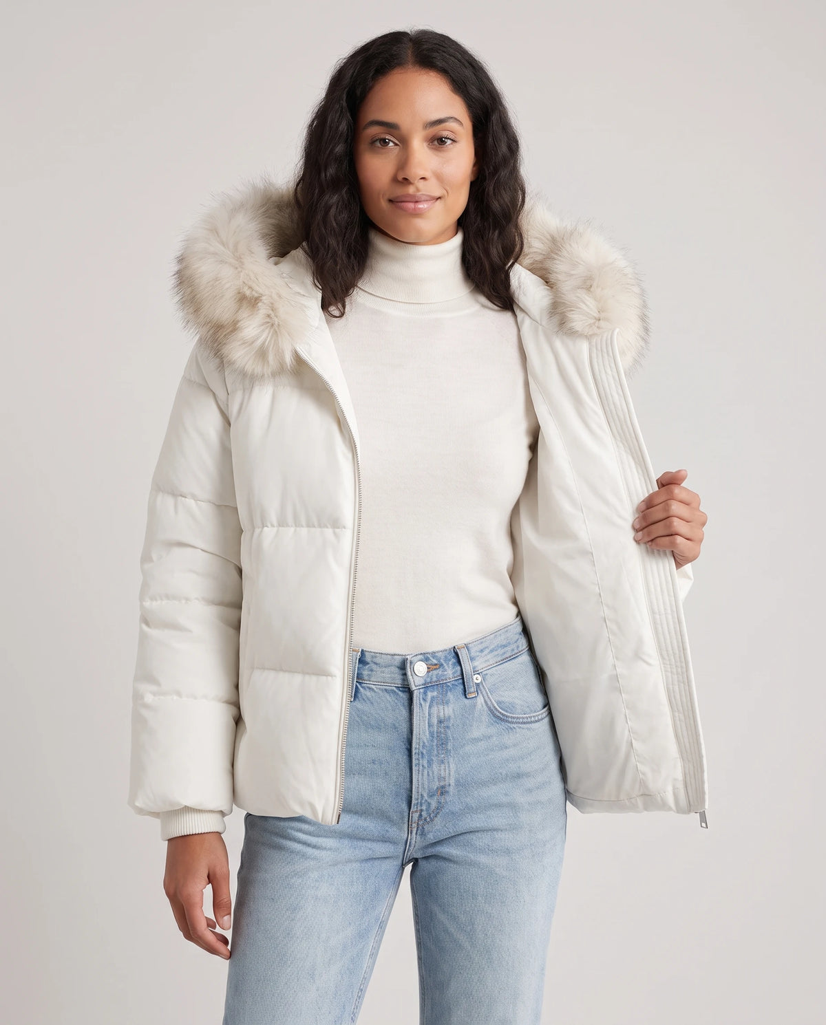 Doudoune courte oversize à capuche fausse fourrure Anna en Blanc, portée ouverte sur un col roulé écru