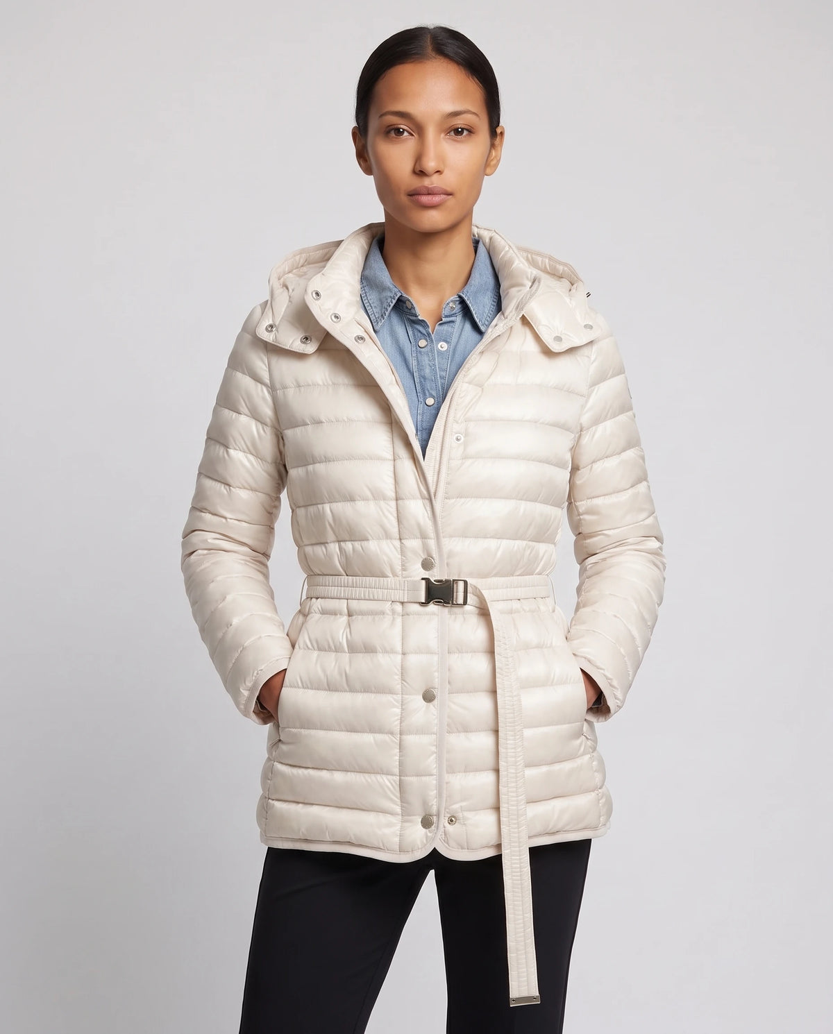 Doudoune légère à capuche et ceinture à boucle Magali en Ivoire, portée ouverte sur une chemise en denim, ceinture bouclée à la taille