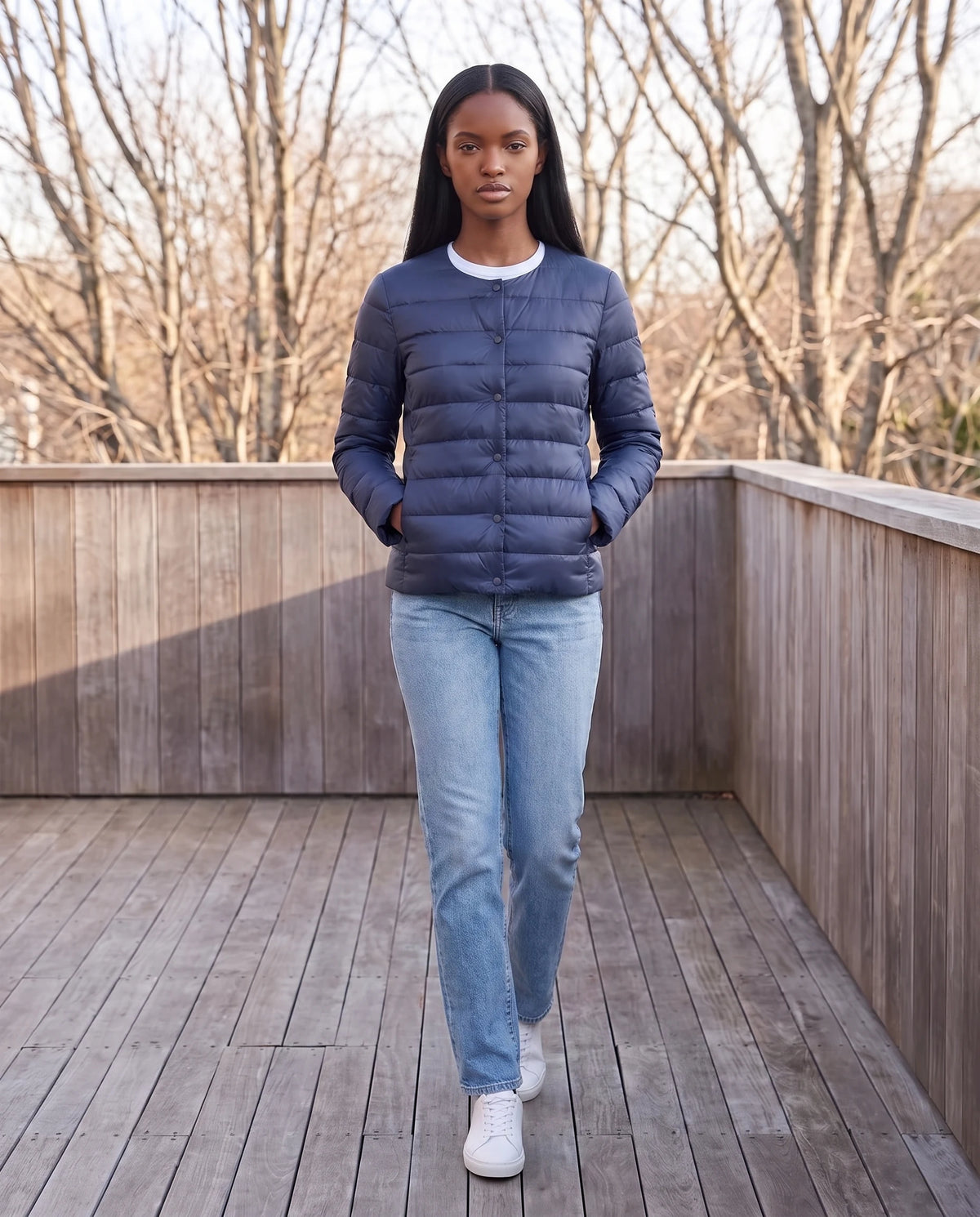 Leichte dünne Steppjacke mit Rundhals Sophie in Marineblau, getragen auf einer Holzterrasse
