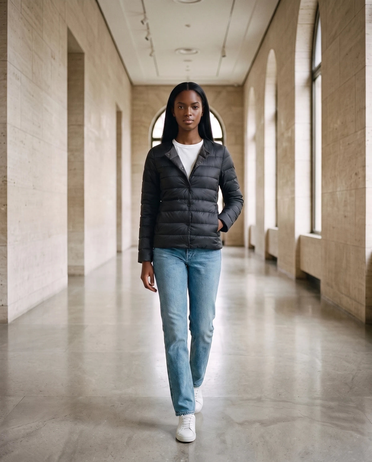 Leichte dünne Steppjacke mit Rundhals Sophie in Schwarz, getragen in einem Museumsgang, Kragen zum V-Ausschnitt umgelegt