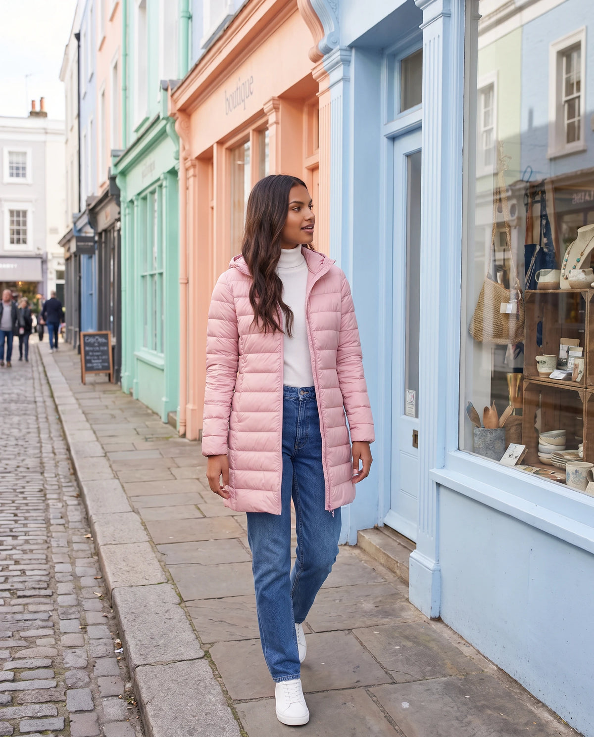 Doudoune légère Nélie en Rose, portée dans une rue aux façades pastel