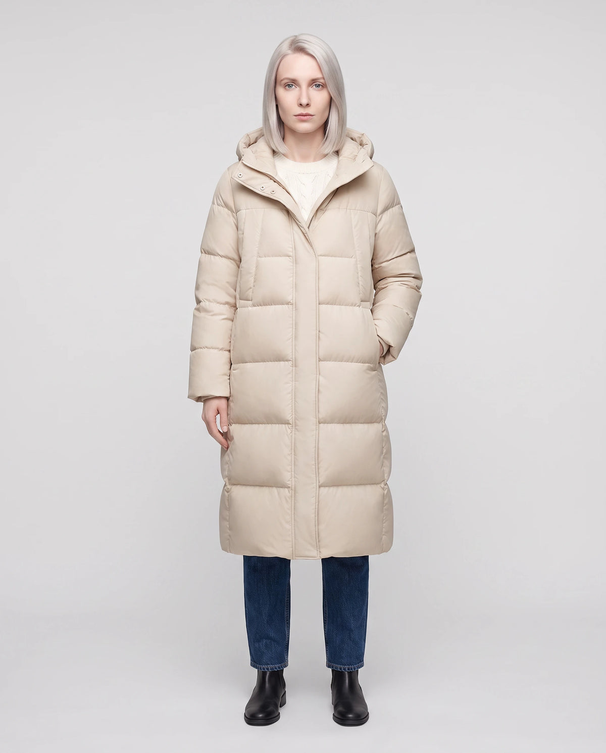 Doudoune longue évasée à capuche déperlante Oriana en Beige Clair, vue de face en pied, zippée au menton, capuche baissée