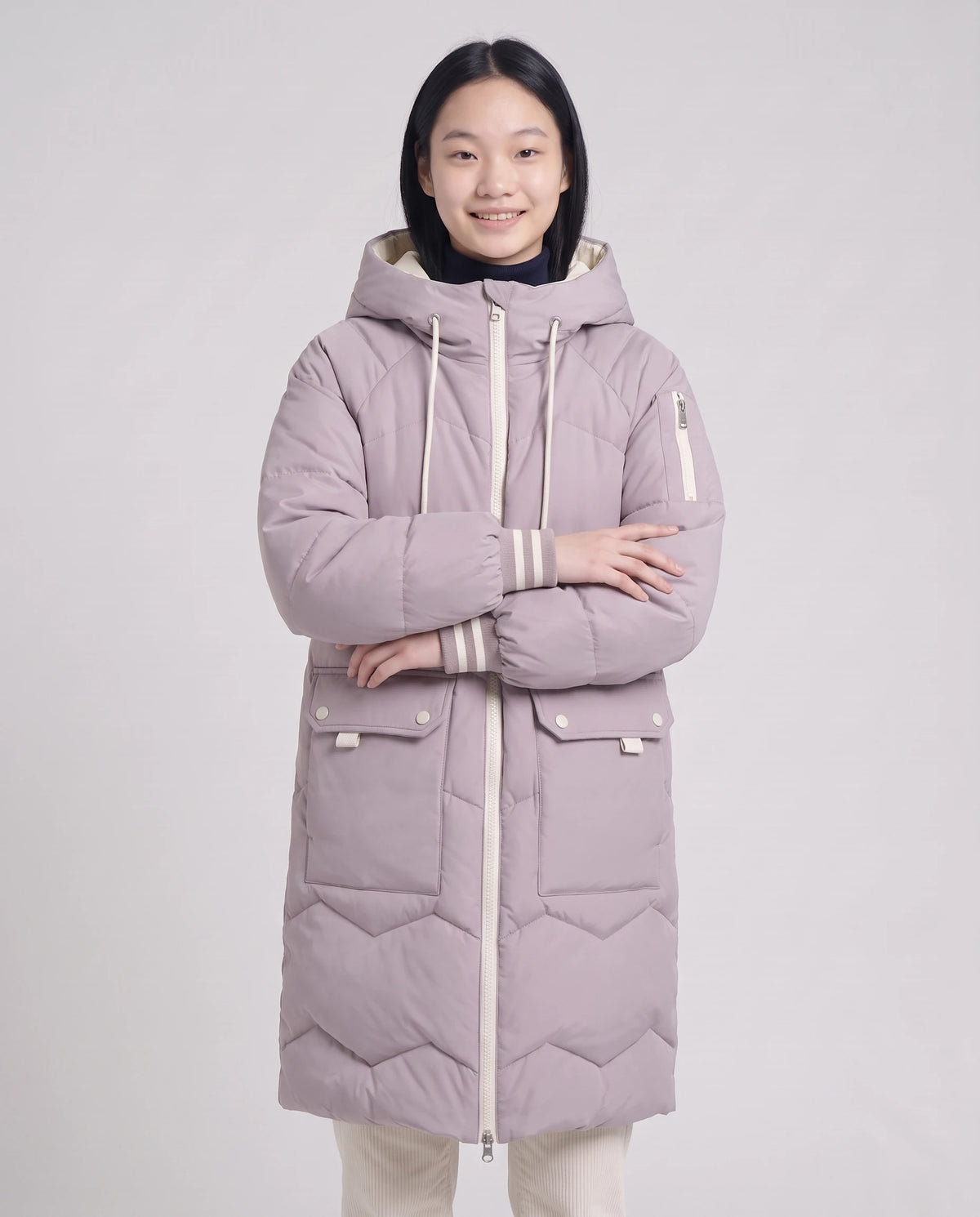 Doudoune longue oversize à chevrons Edmée mauve poudré, plan rapproché de face, bras croisés